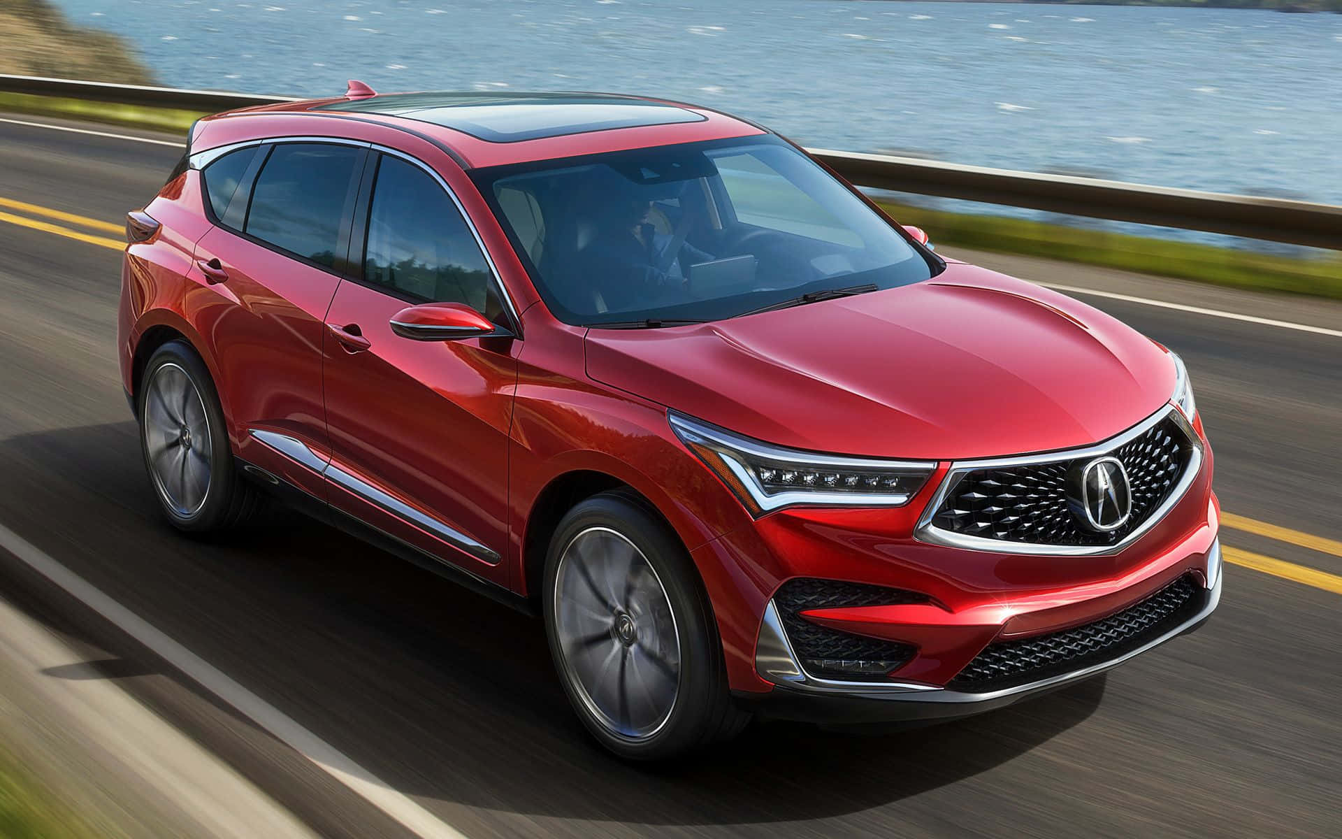 Acura Rdx 桌布 壁紙 — 一輛充滿活力的紅色Acura SUV沿著海岸高速公路疾馳，帶有動態模糊和藍色海洋背景。