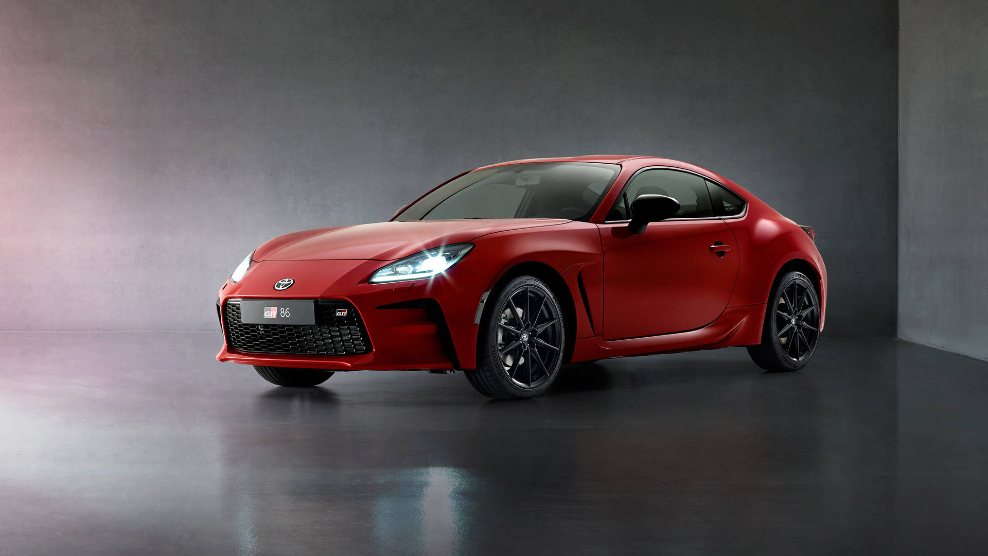 紅色豐田86跑車在極簡工作室中，帶有戲劇性燈光。 — Toyota Supra 壁紙
