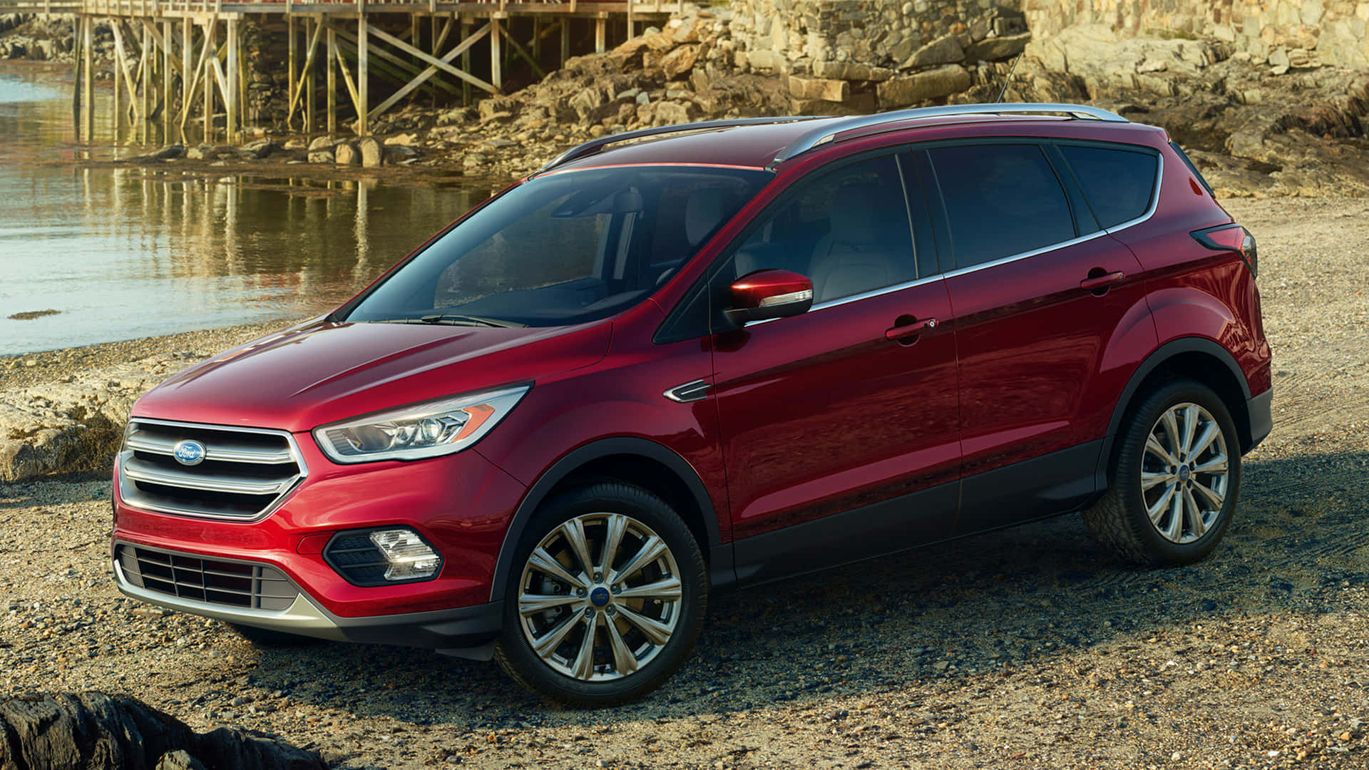Ford Escape 桌布 壁紙 — 一輛亮紅色的福特Escape SUV停泊在岩石海岸線旁，背景有平靜的水面和木製碼頭。