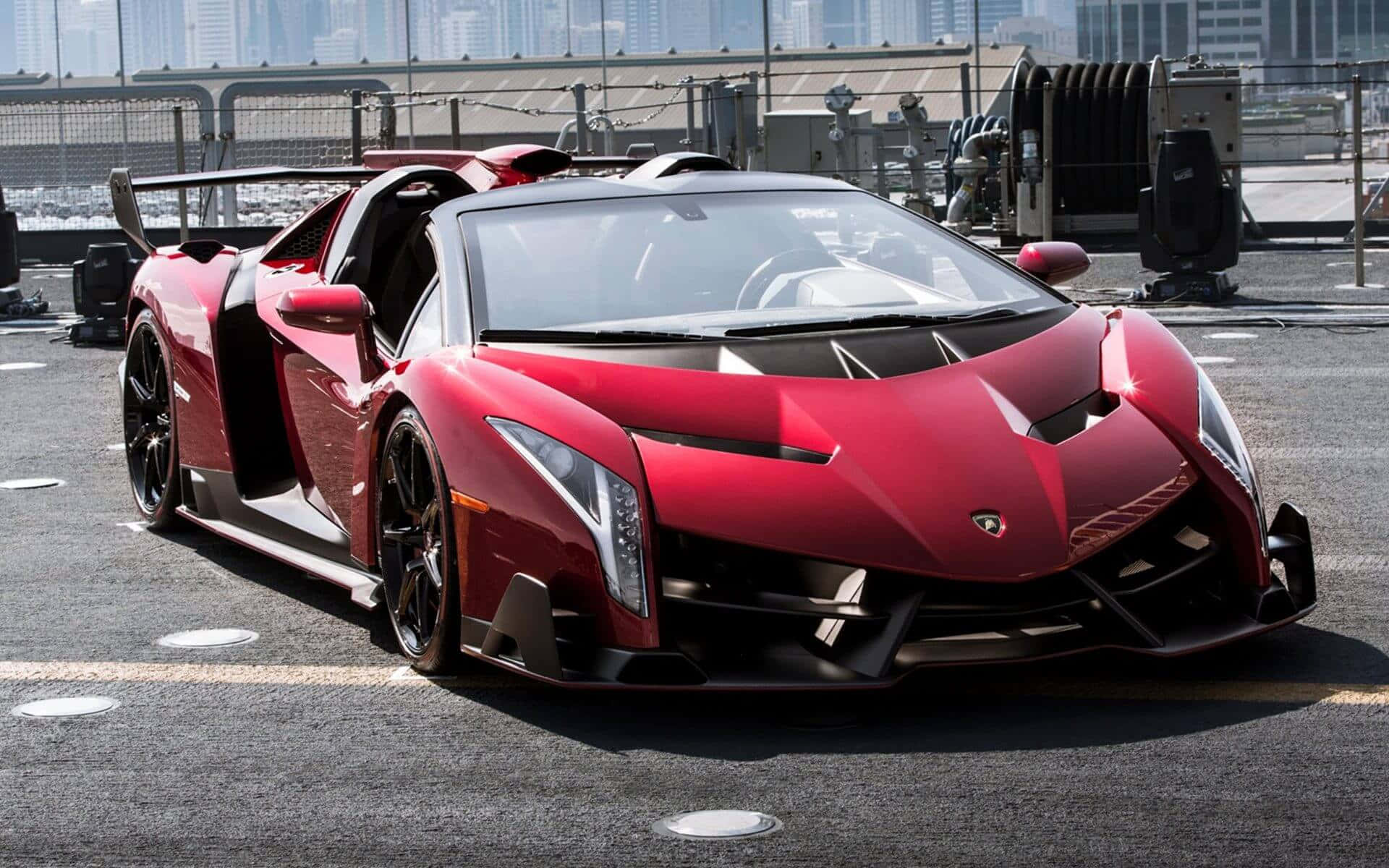 Lamborghini Veneno 桌布 壁紙 — 一輛搶眼的紅色藍寶堅尼 Veneno 敞篷跑車停放在屋頂上，背景是城市天際線。