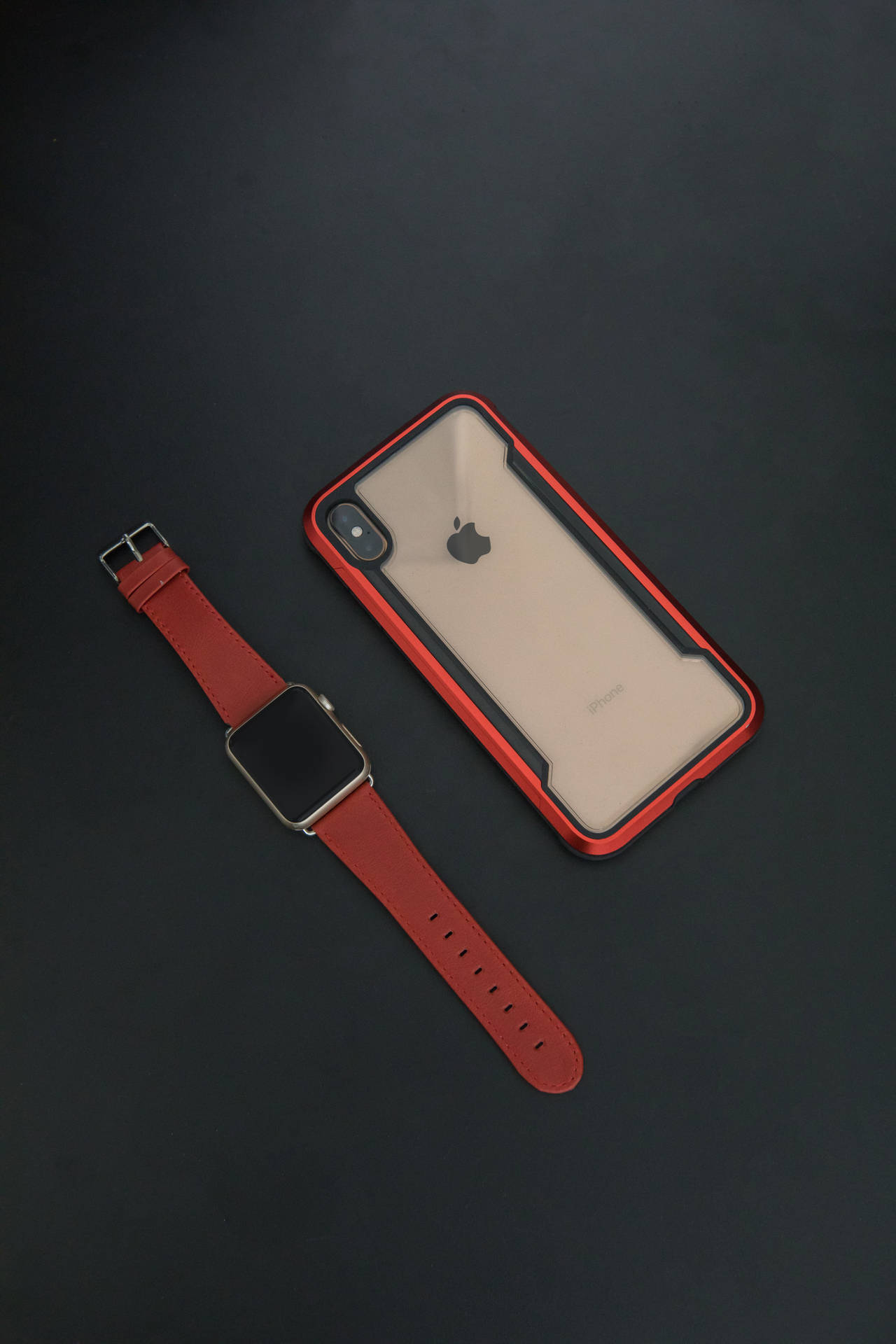紅色 Apple Watch 和 iPhone 保護殼在深色背景上 — iPhone 11 Pro Max 壁紙