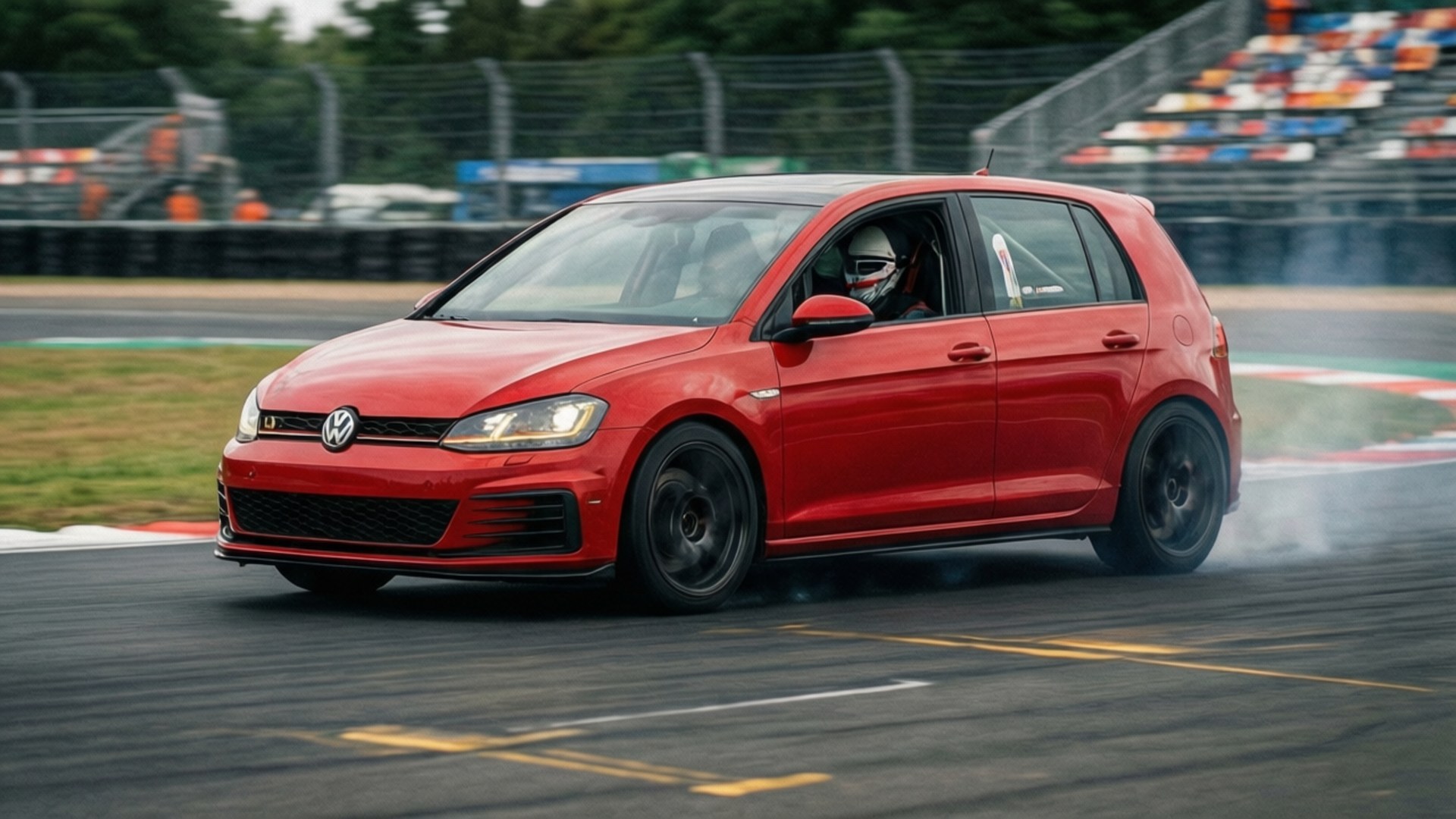 Track Day GTI 壁紙 — 一輛紅色福斯Golf GTI在賽道彎道飄移，後輪冒出滾滾濃煙。