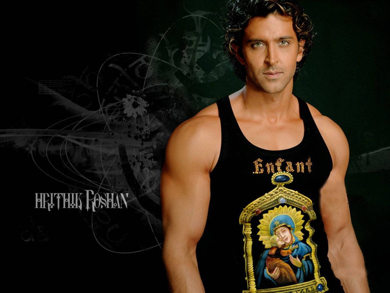 actor 桌布 壁紙 — Hrithik Roshan 自信地擺姿勢，身穿印有宗教圖標的黑色背心，背景為深色抽象圖案。