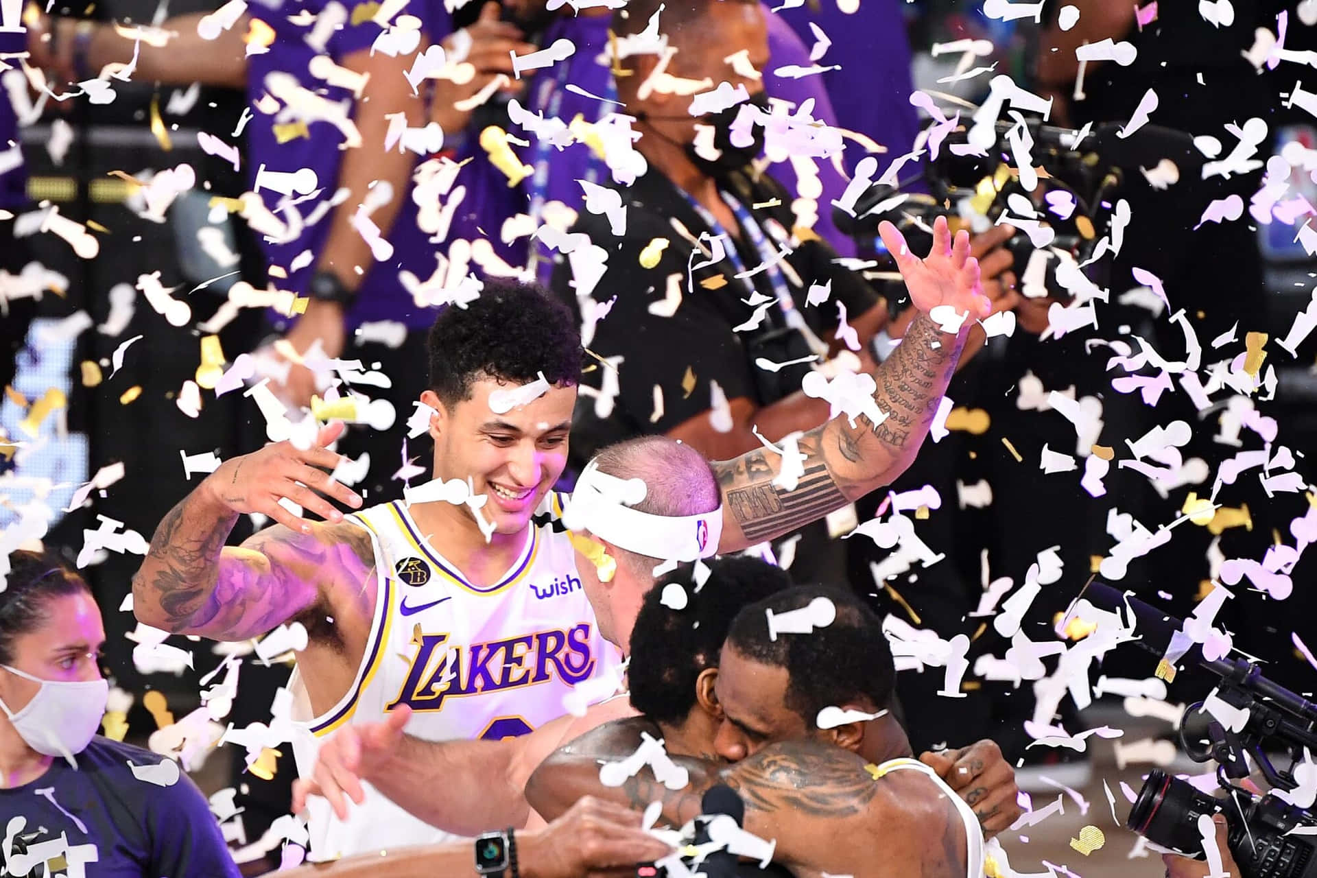  壁紙 — 湖人籃球運動員慶祝勝利，紫色和金色的紙屑在他們周圍飄落。