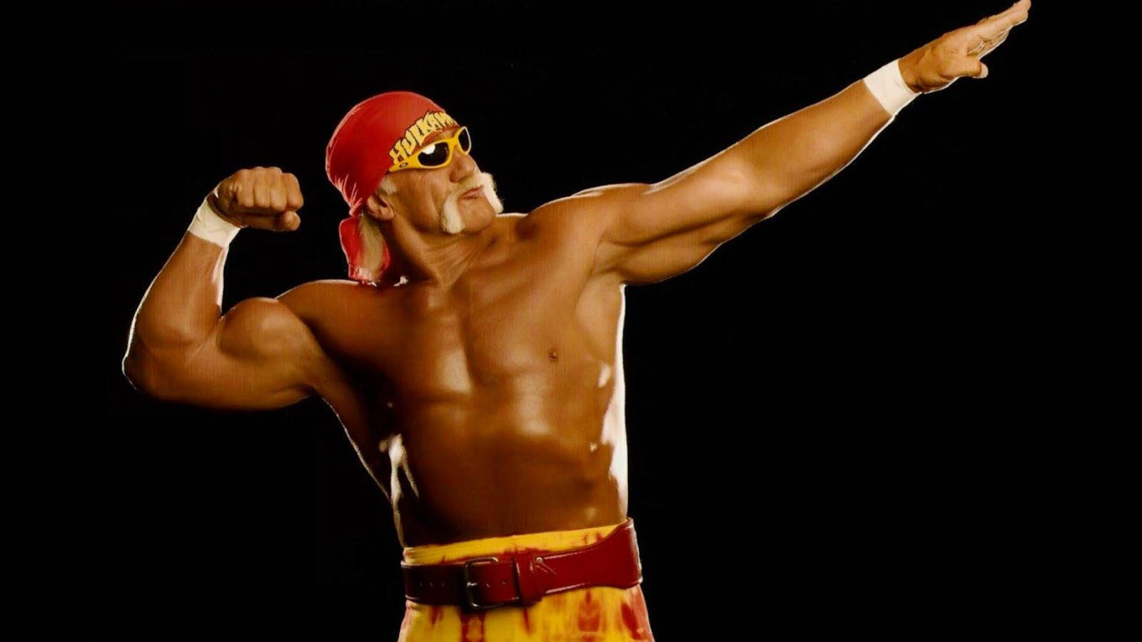 Hulk Hogan 桌布 壁紙 — Hulk Hogan 在黑色背景前擺出戲劇性姿勢，繃緊肌肉並向前指。