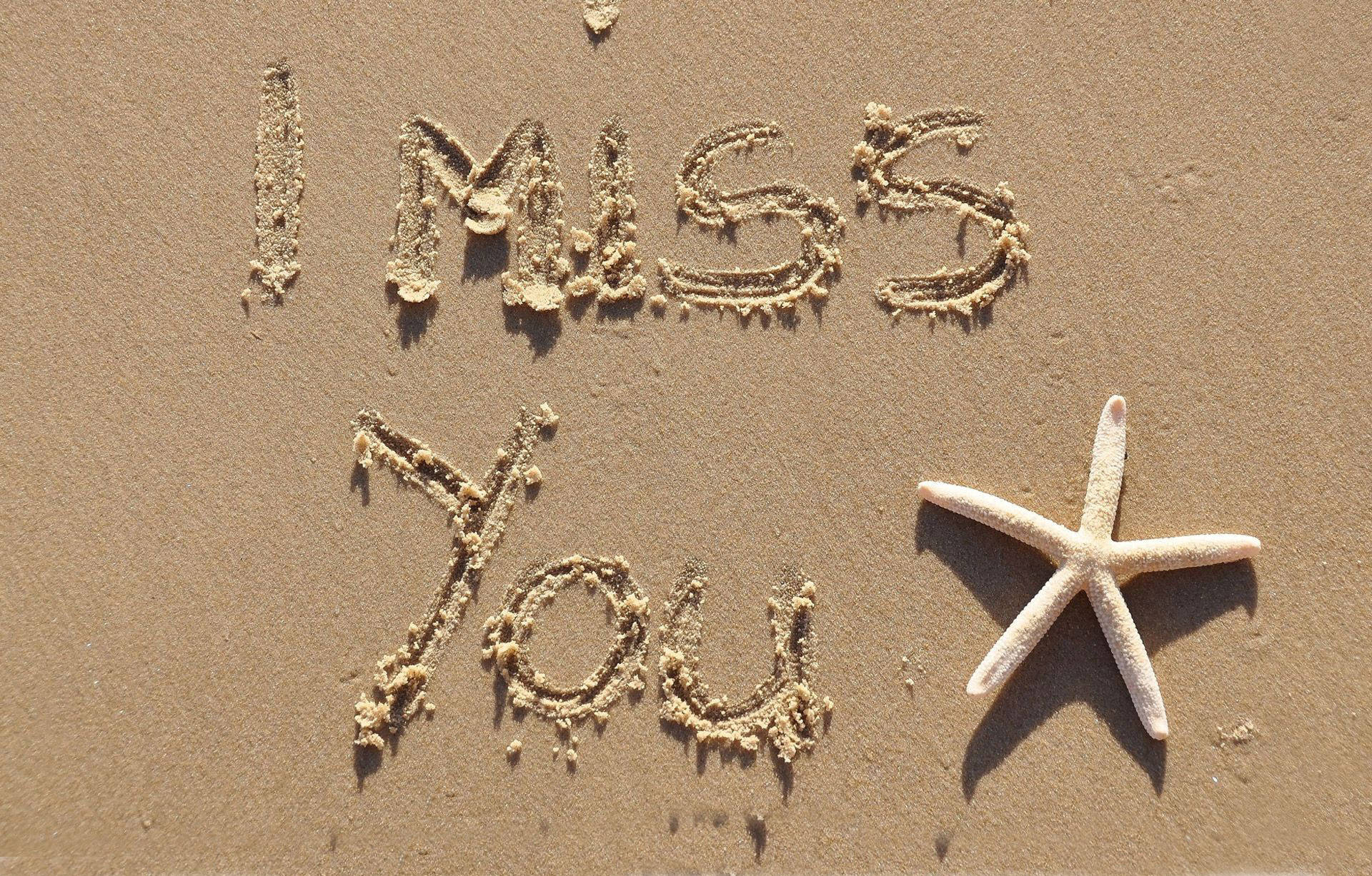 I Miss You 桌布 壁紙 — 「I MISS YOU」這幾個字寫在沙灘的沙子上，旁邊還有一顆海星。
