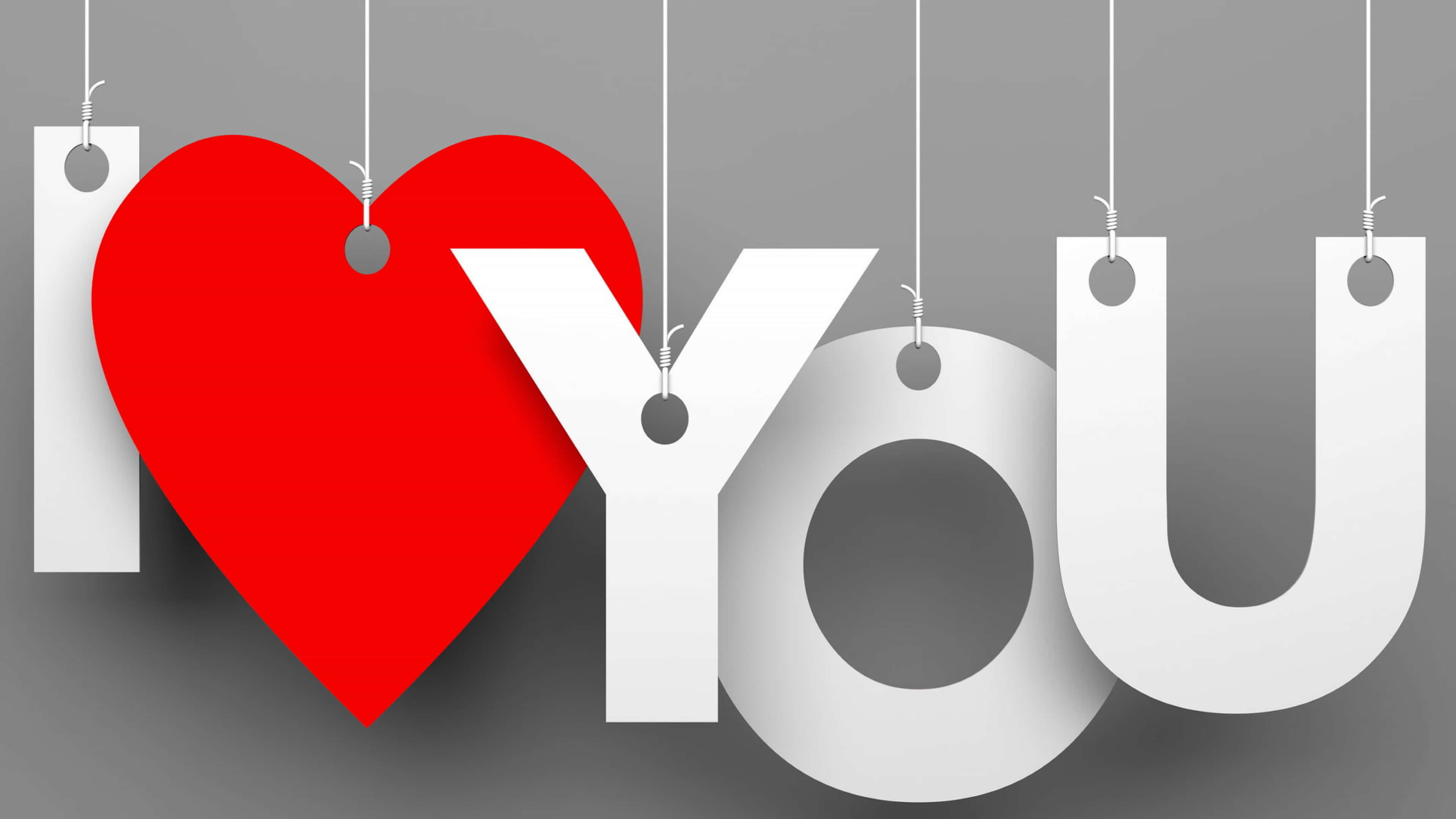 4K Love 桌布 壁紙 — 「I ❤️ YOU」這句話以粗體白色字母和一個鮮紅色心形懸掛在柔和灰色背景上。