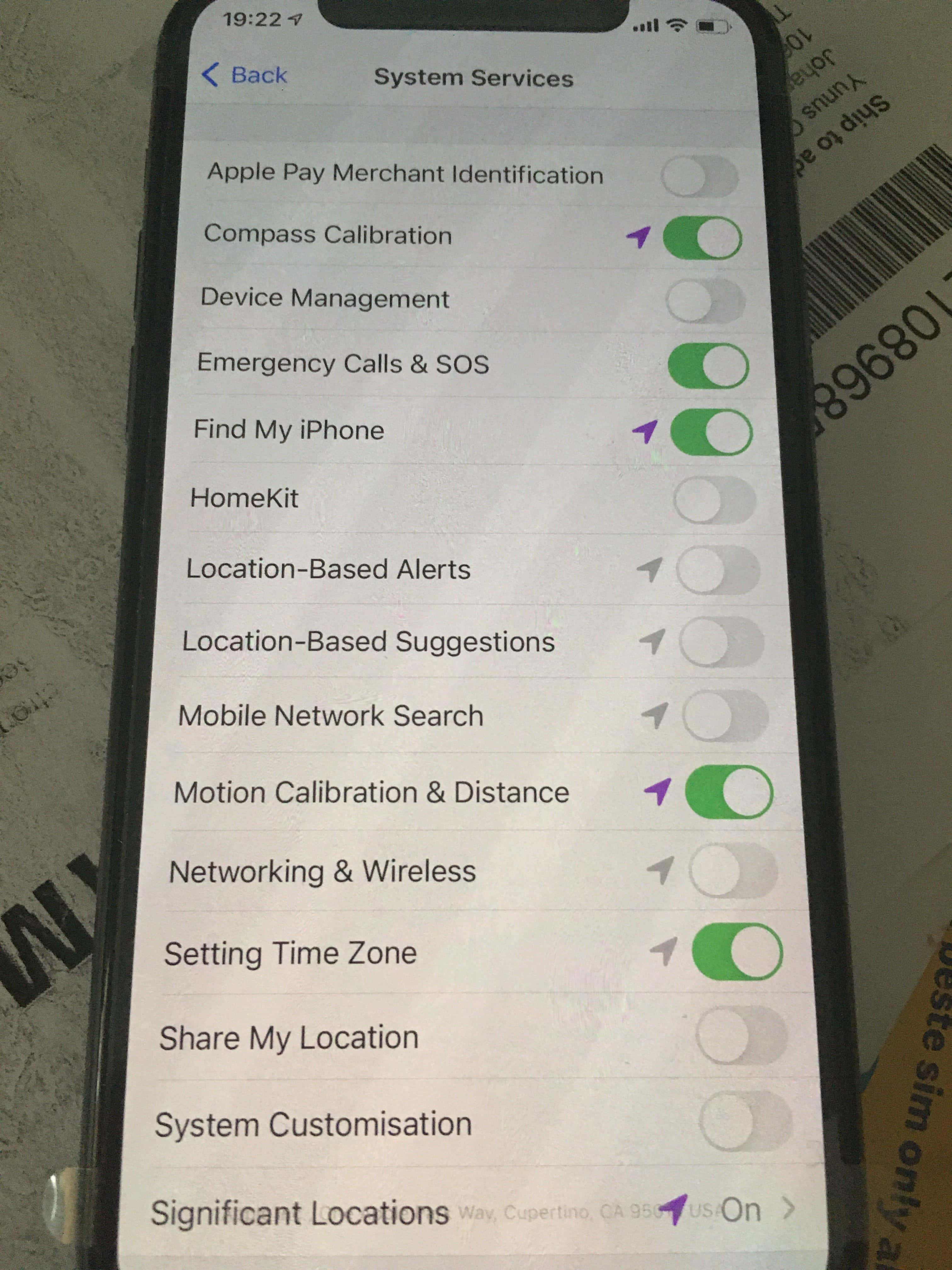 iPhone 桌布 壁紙 — iPhone 螢幕特寫，顯示系統服務設定，並附有尋找我的 iPhone 和動作校正等功能的切換開關。