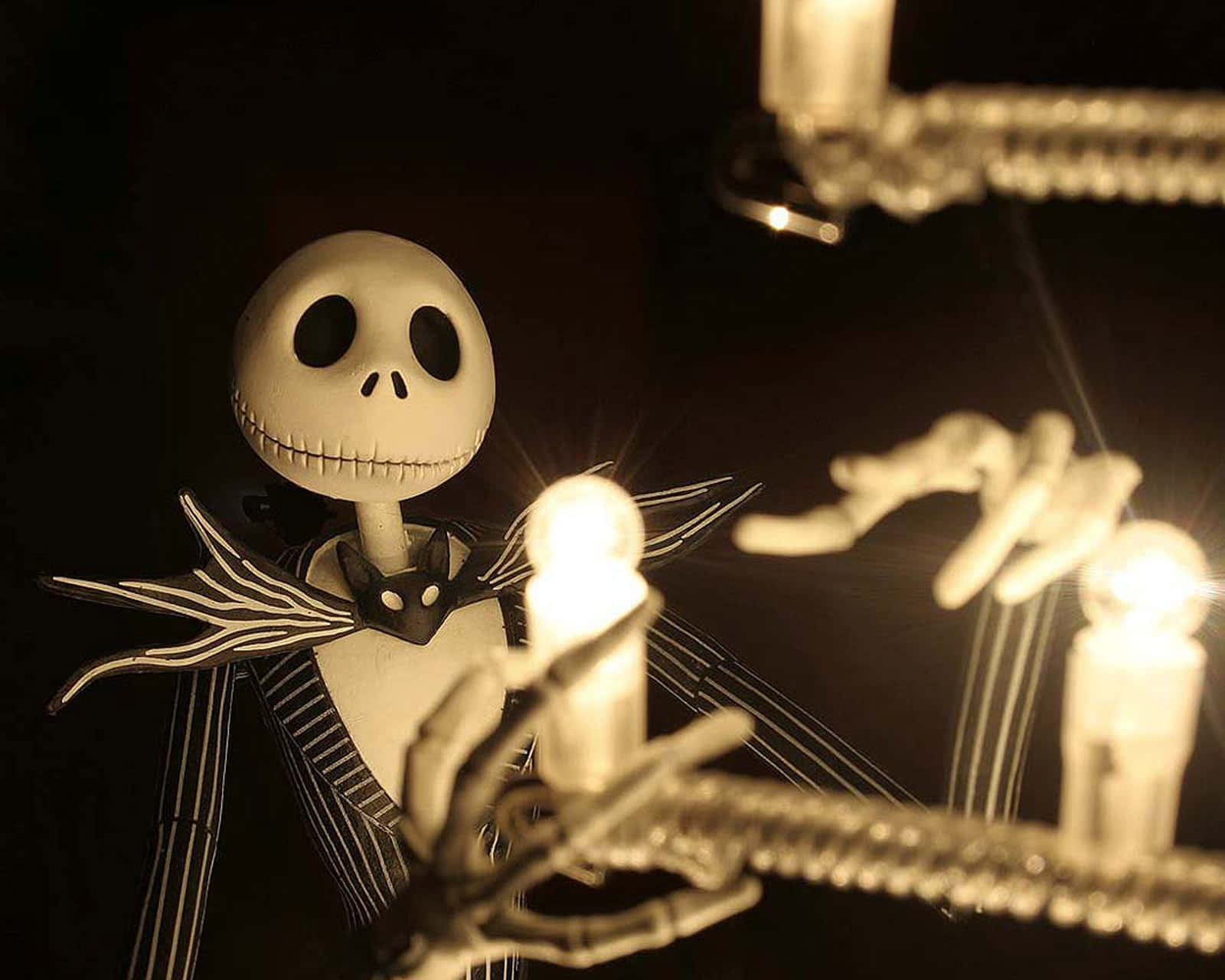 聖誕夜驚魂 桌布 壁紙 — Jack Skellington 在一個黑暗的房間裡拿著發光的蠟燭，房間裡有吊燈和伸出的骷髏手。