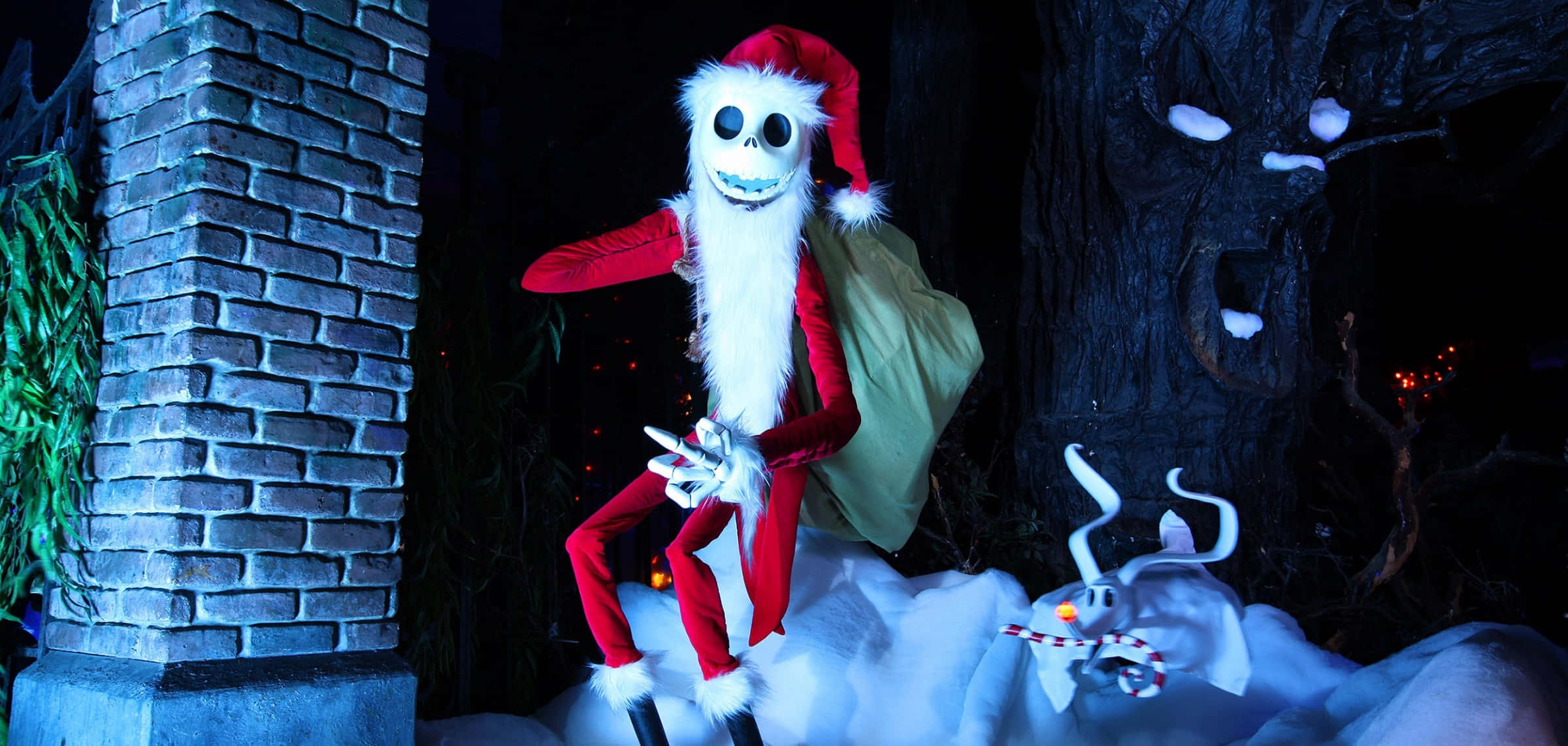 傑克·史克林頓 桌布 壁紙 — Jack Skellington 穿著紅色聖誕老人服裝坐在雪地上，旁邊有一隻發光的馴鹿，在夜晚黑暗陰森的森林中。