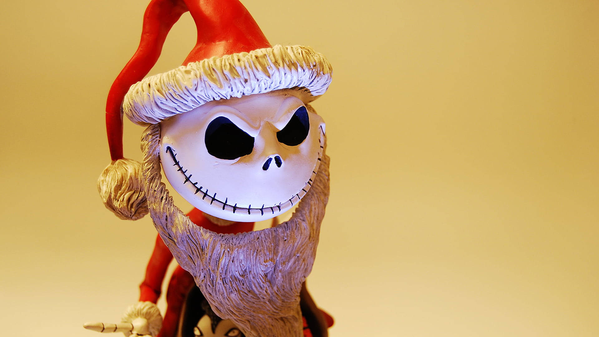 傑克·史克林頓 桌布 壁紙 — Jack Skellington 戴上紅色聖誕帽，帽邊白色，背景為溫暖的黃色，特寫鏡頭。