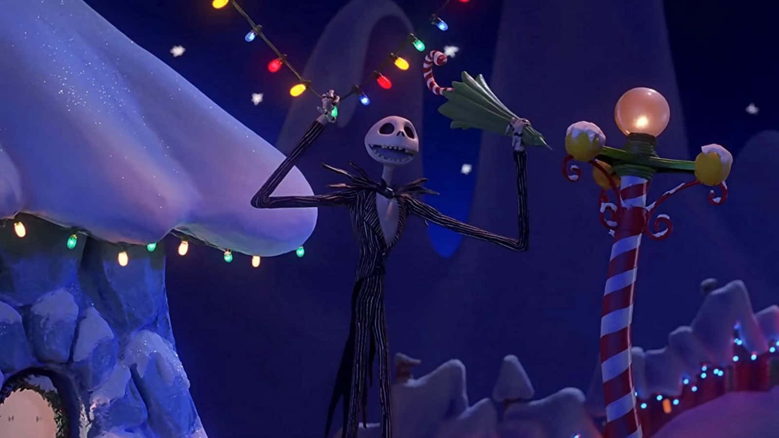 傑克·史克林頓 桌布 壁紙 — Jack Skellington 在雪夜的萬聖節小鎮中，在彩色燈串下跳舞。