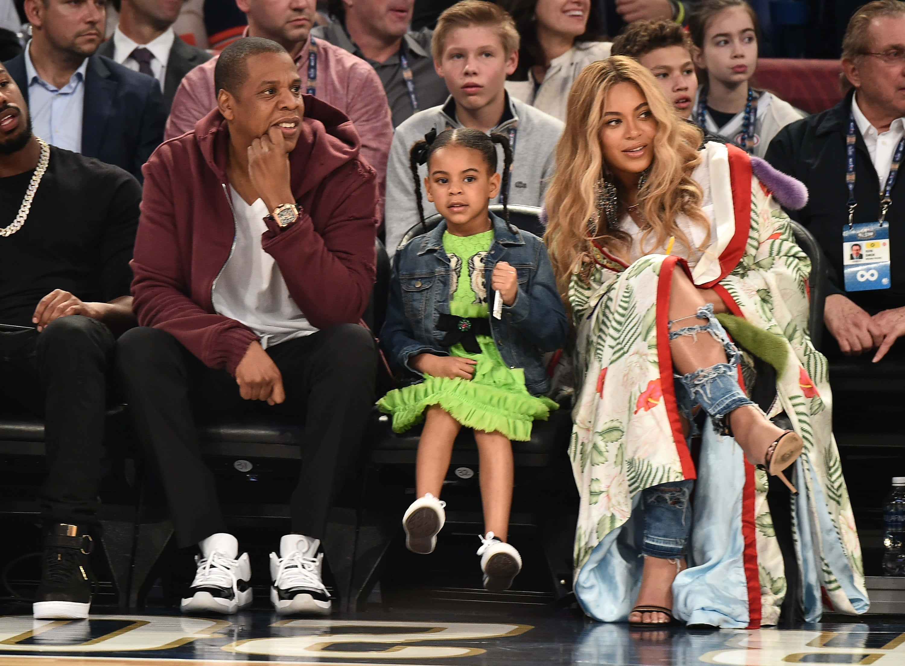 寶寶 桌布 壁紙 — Jay Z、Beyoncé 和他們的女兒 Blue Ivy 一起坐在籃球場邊，周圍都是觀眾。