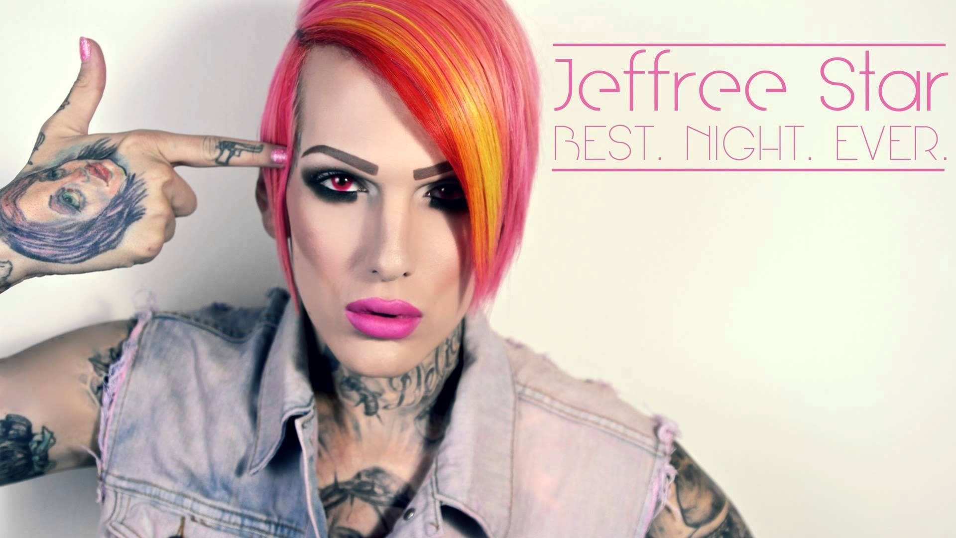 Jeffree Star 桌布 壁紙 — Jeffree Star 擁有充滿活力的粉紅色和橙色頭髮，穿著牛仔背心和誇張化妝，手指指向太陽穴。