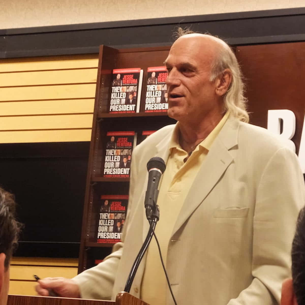 政治 桌布 壁紙 — Jesse Ventura 在簽書會上發言，他的書《They Killed Our President》展示在他身後。