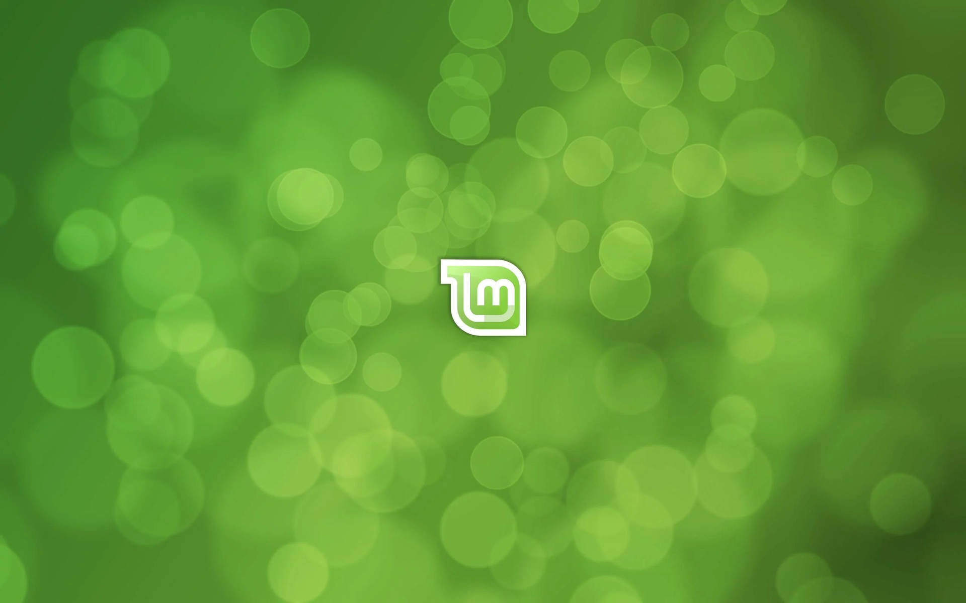 綠色散景背景，中央有白色標誌 — Linux 壁紙