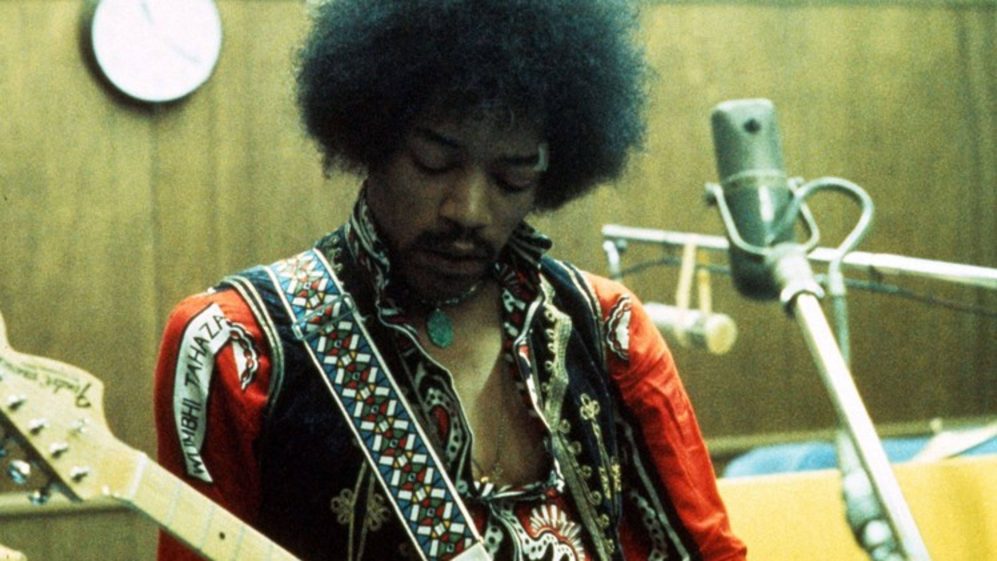 Celebrity 桌布 壁紙 — Jimi Hendrix 在錄音室彈奏電吉他，配有復古麥克風和木鑲板。