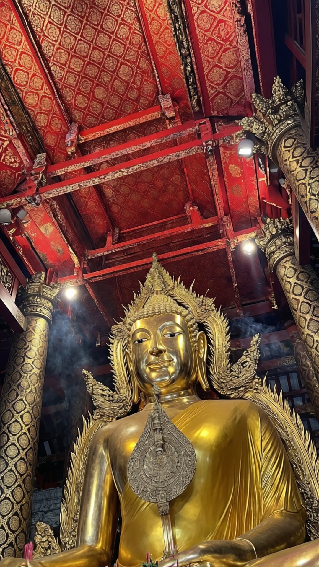 Buddha Tooth Relic 壁紙 — 一座高聳的金色佛像在華麗的紅金寺廟天花板下靜坐，周圍有香煙飄散。