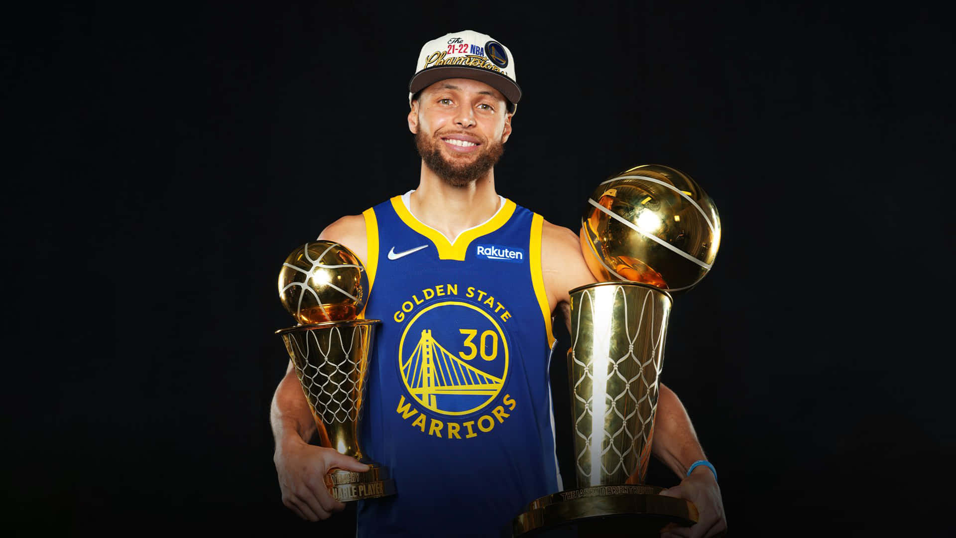 史蒂芬柯瑞身穿金州勇士隊球衣，手持兩座NBA冠軍獎盃。 — 史蒂芬·柯瑞 壁紙