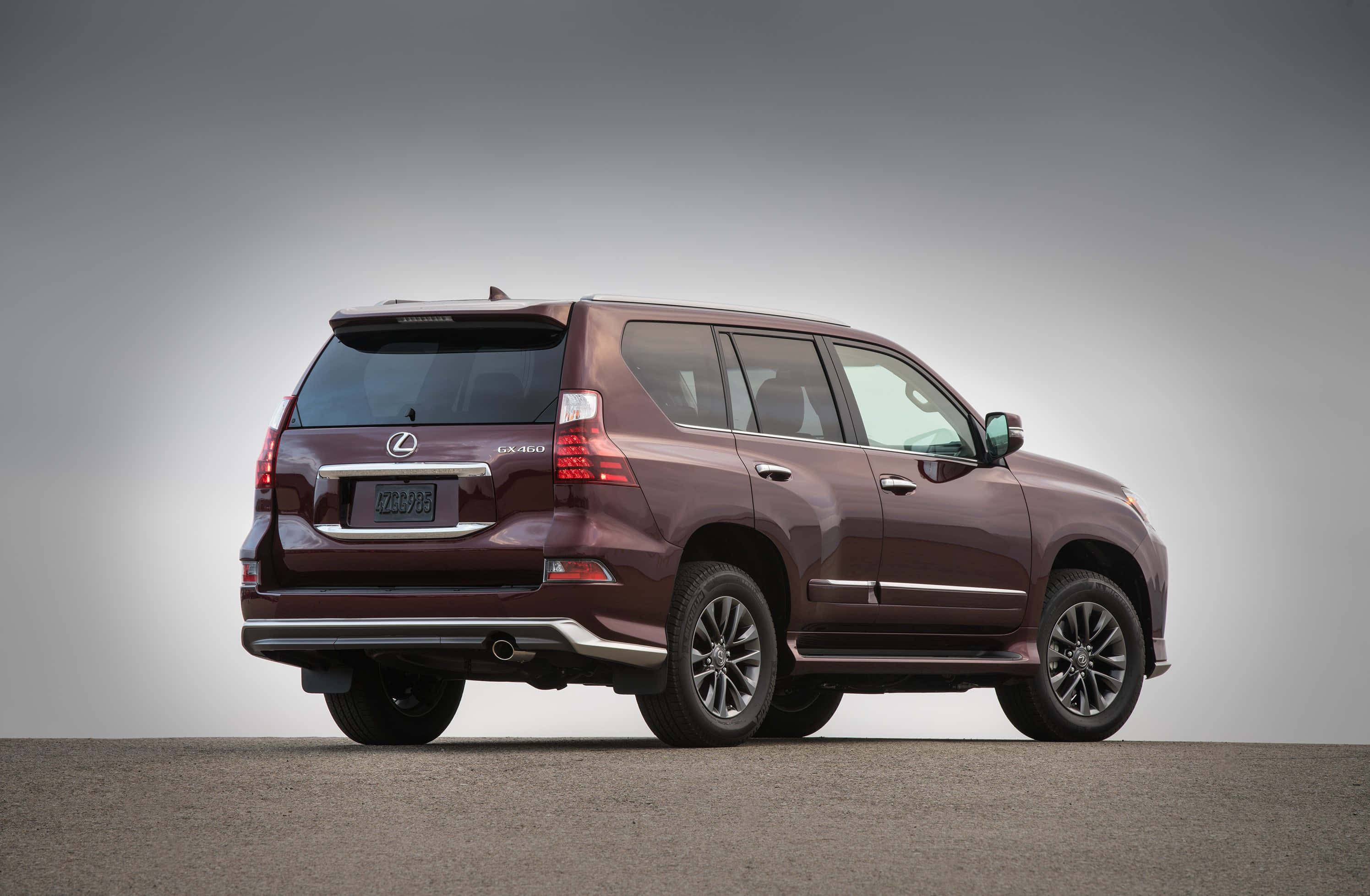 Lexus Gx 460 桌布 壁紙 — 酒紅色 Lexus GX SUV 以四分之三後視圖顯示，背景為中性灰色攝影棚。