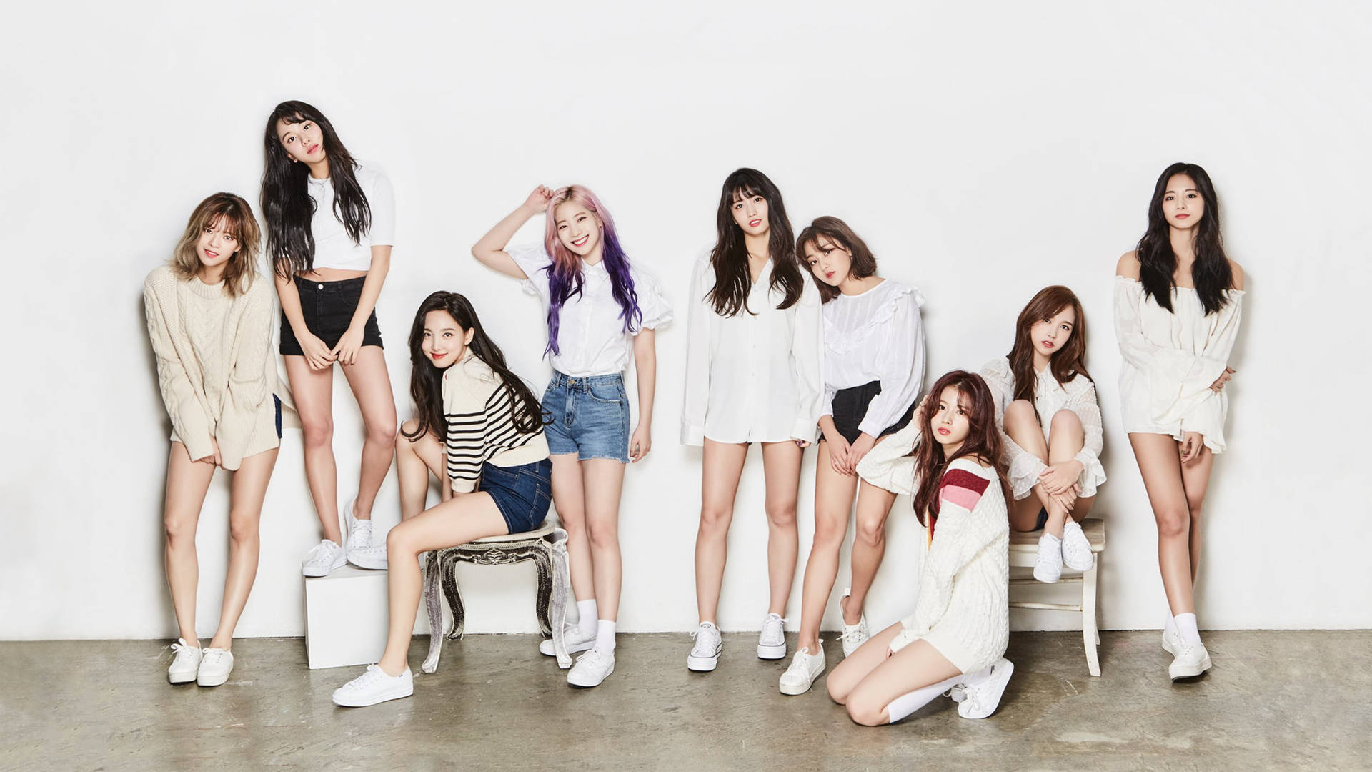 九位年輕女性穿著休閒白色服裝在工作室中擺姿勢。 — Twice 壁紙