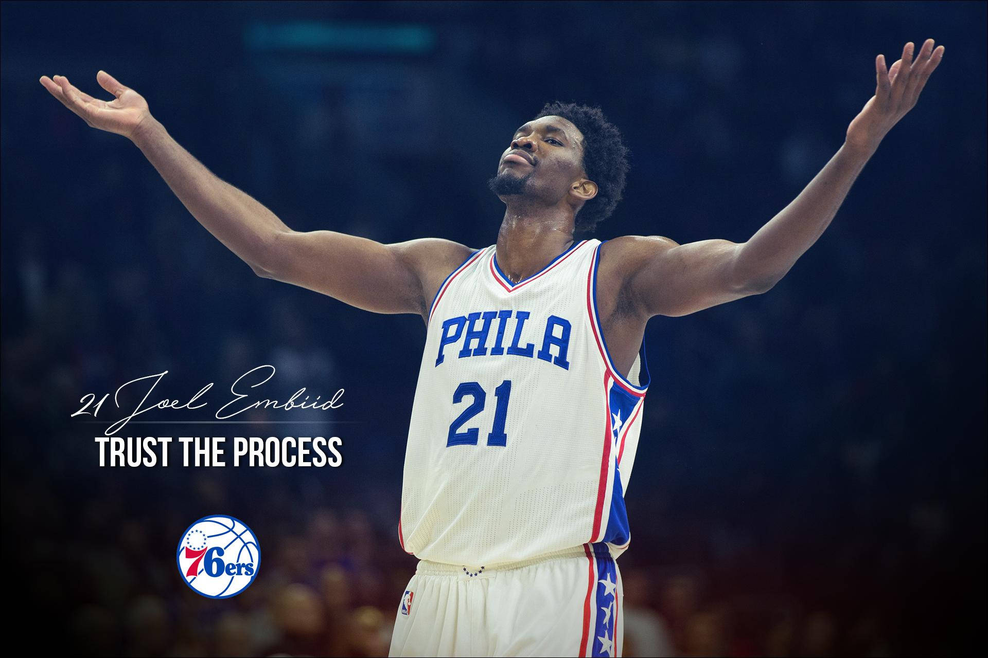 喬爾·恩比德身穿白色球衣高舉雙臂慶祝，附有「Trust the Process」文字。 — NBA 壁紙