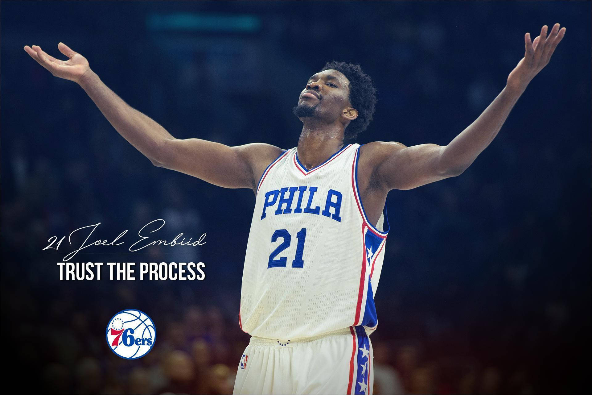Embiid 桌布 壁紙 — Joel Embiid 身穿白色76ers球衣，在場館燈光下張開雙臂的勝利姿勢。