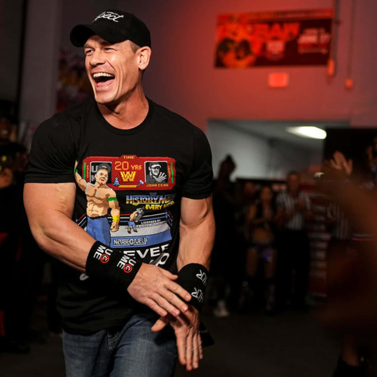 約翰·希南 桌布 壁紙 — John Cena 穿著WWE 20週年慶祝T恤，背景中粉絲歡呼，開懷大笑。