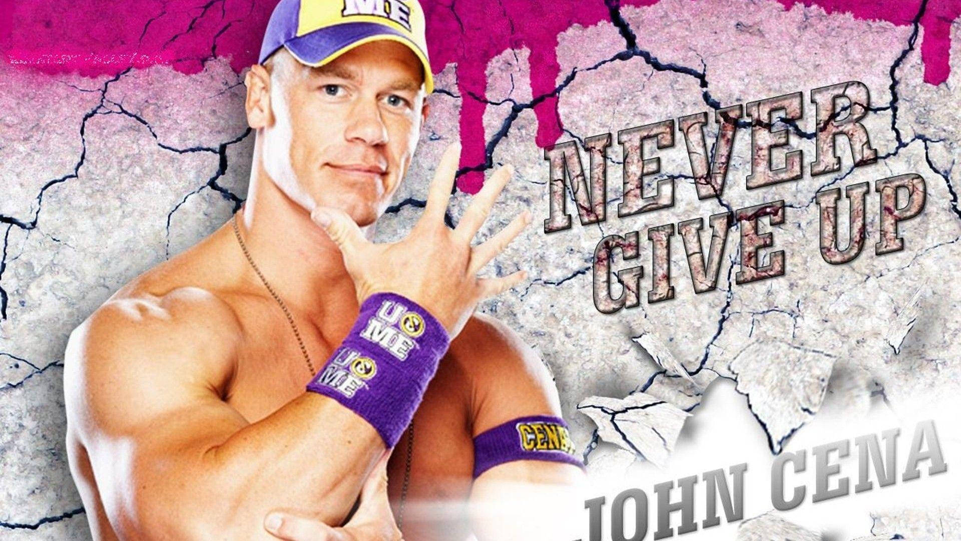 約翰·希南 桌布 壁紙 — John Cena 自信地擺姿勢，配上他的標誌性口號「Never Give Up」，背景是裂開的混凝土牆面，帶有鮮豔的粉紅色潑濺。