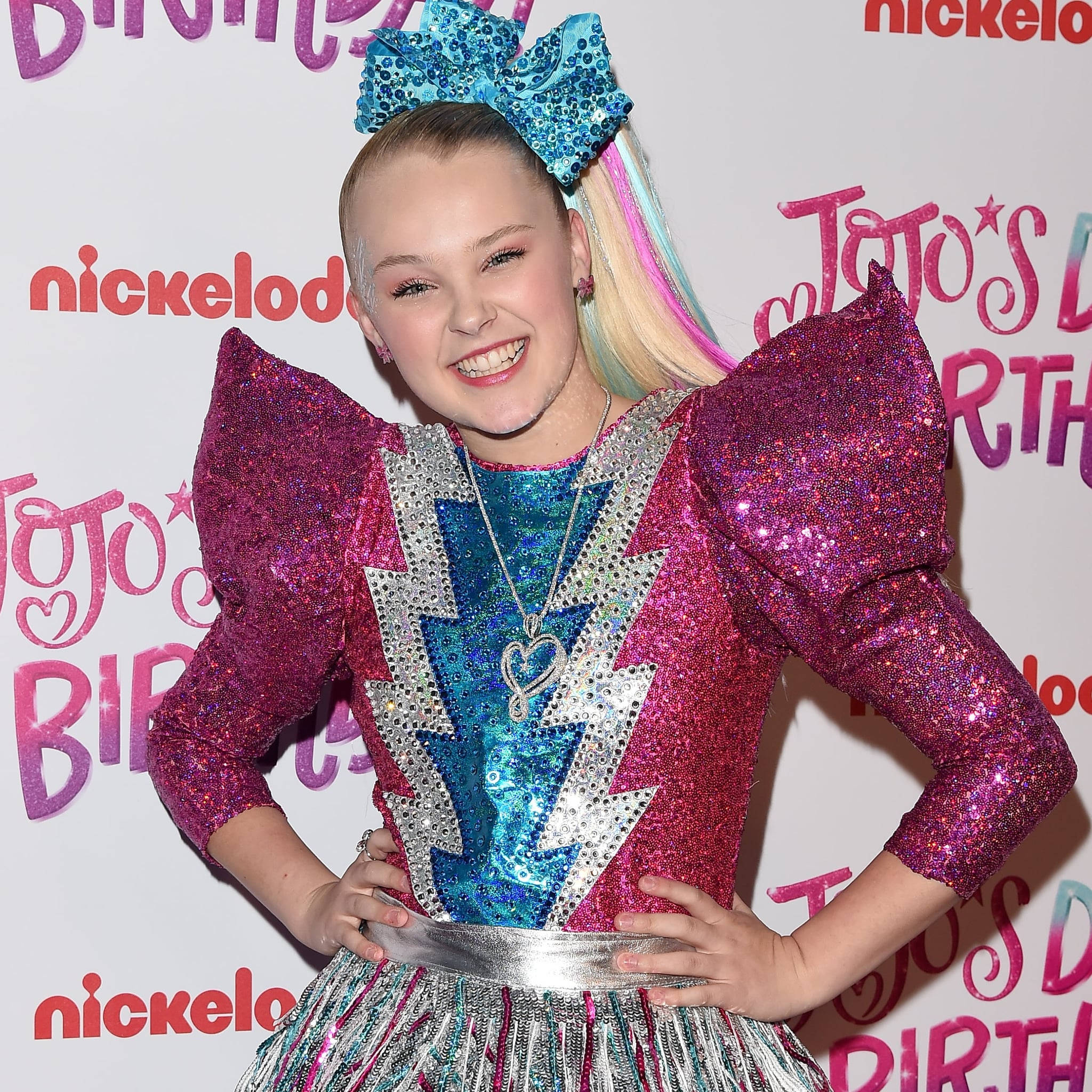 JoJo Siwa 桌布 壁紙 — JoJo Siwa 在Nickelodeon生日活動中，身穿閃閃發光的粉藍色閃電裙，搭配巨型亮片蝴蝶結，光彩奪目。