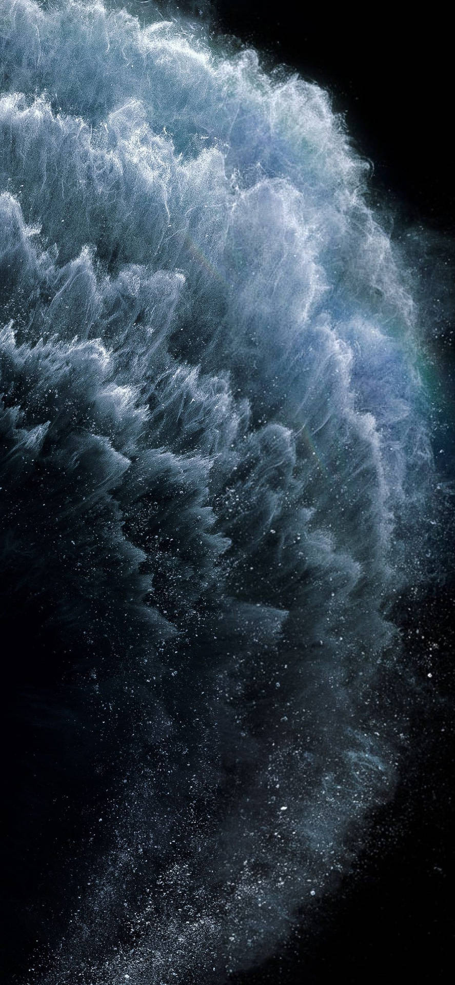 巨大的海浪帶著白色泡沫衝擊黑暗背景。 — iPhone 11 壁紙