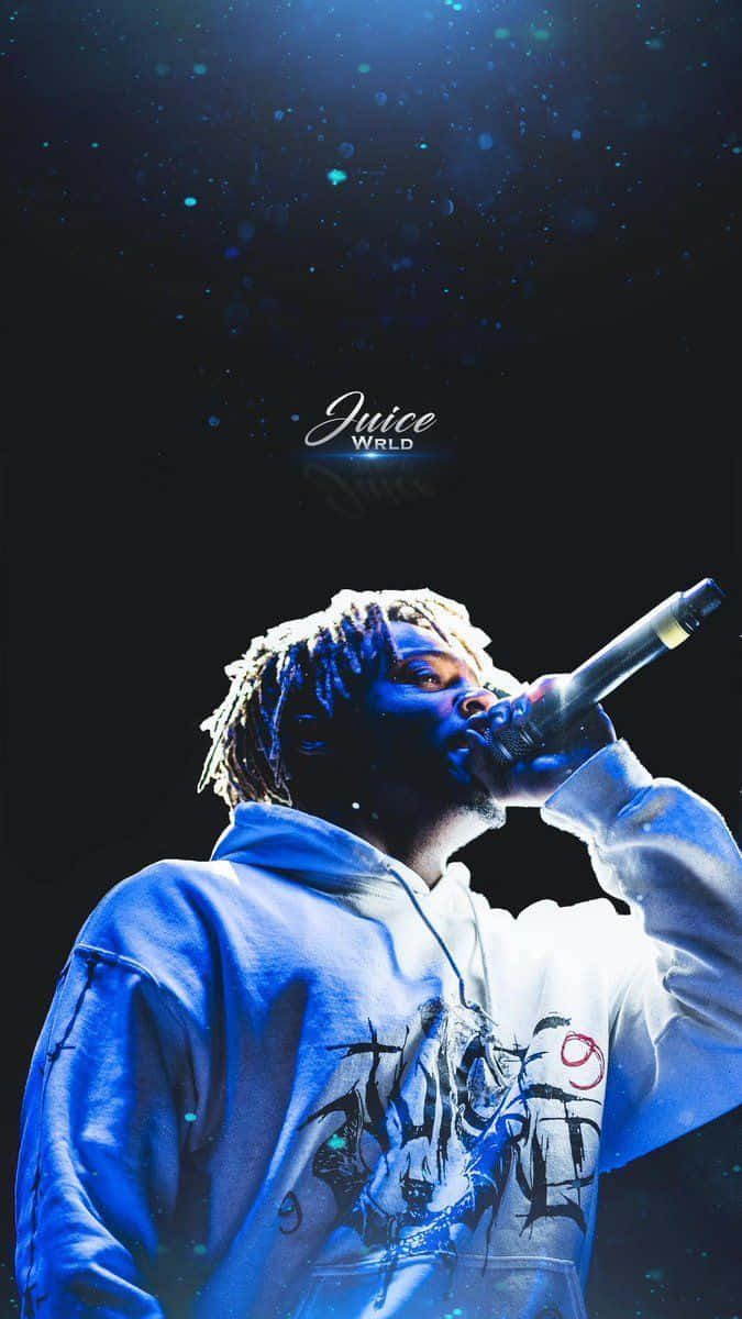 Rappers 桌布 壁紙 — Juice WRLD 在戲劇性的藍色舞台燈光下，熱情地對著麥克風表演，黑暗背景中漂浮著閃閃發光的粒子。