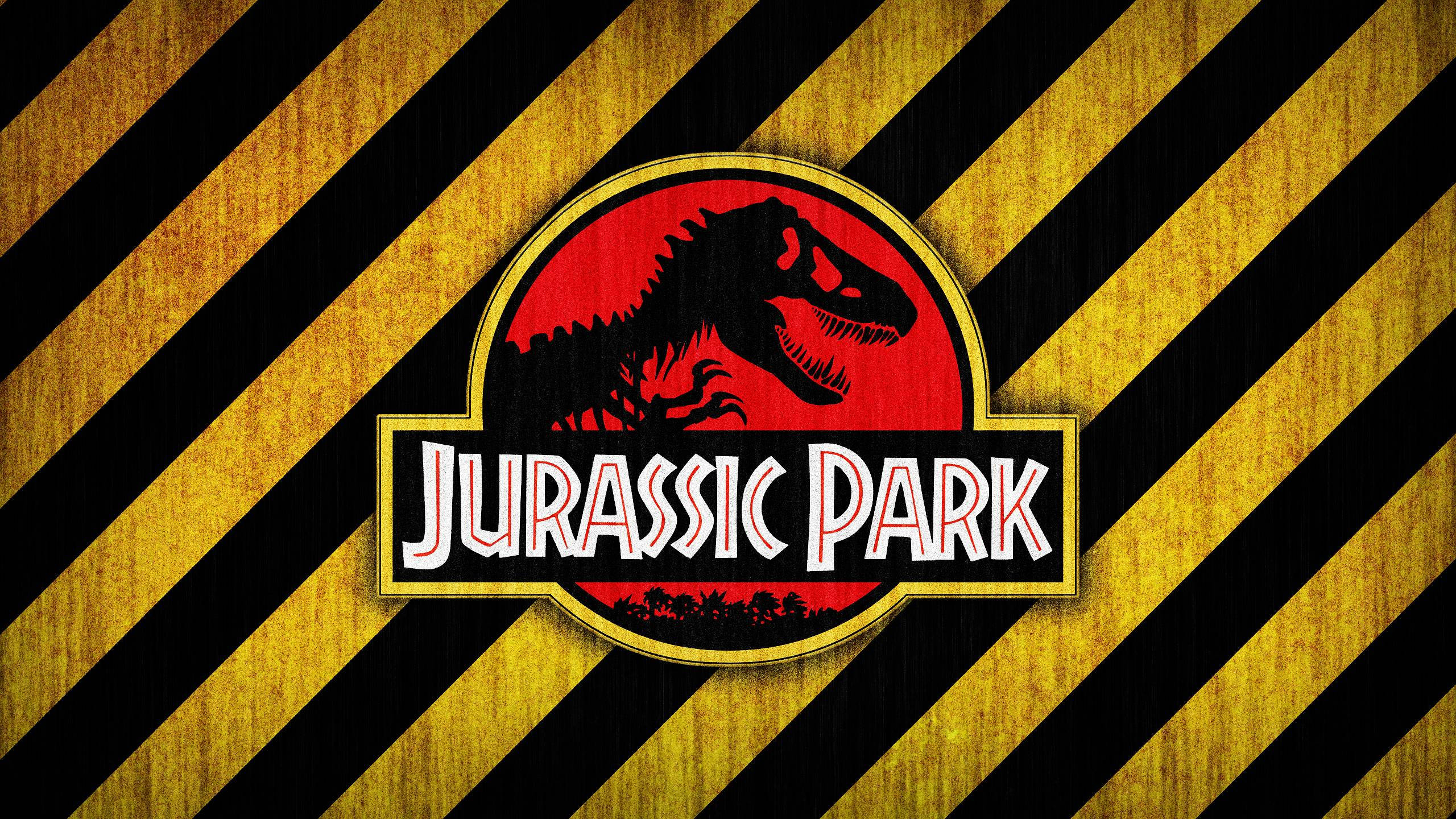 侏羅紀公園 桌布 壁紙 — Jurassic Park 標誌，紅色背景上有一隻咆哮的 T-Rex 剪影，並以黃色和黑色危險條紋框住。