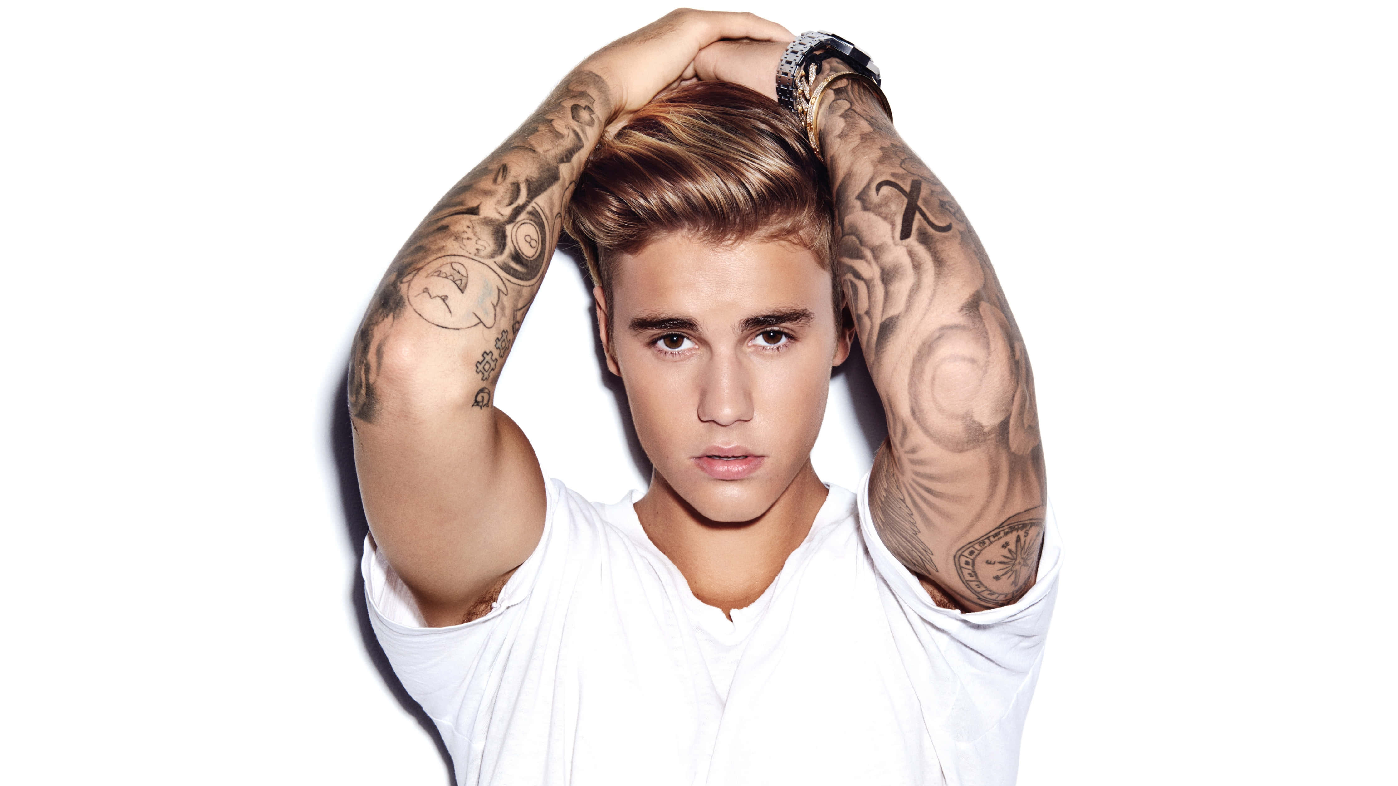 Justin Bieber 2021 桌布 壁紙 — Justin Bieber 擺姿勢，紋身手臂舉起放在腦後，背景為純白色。