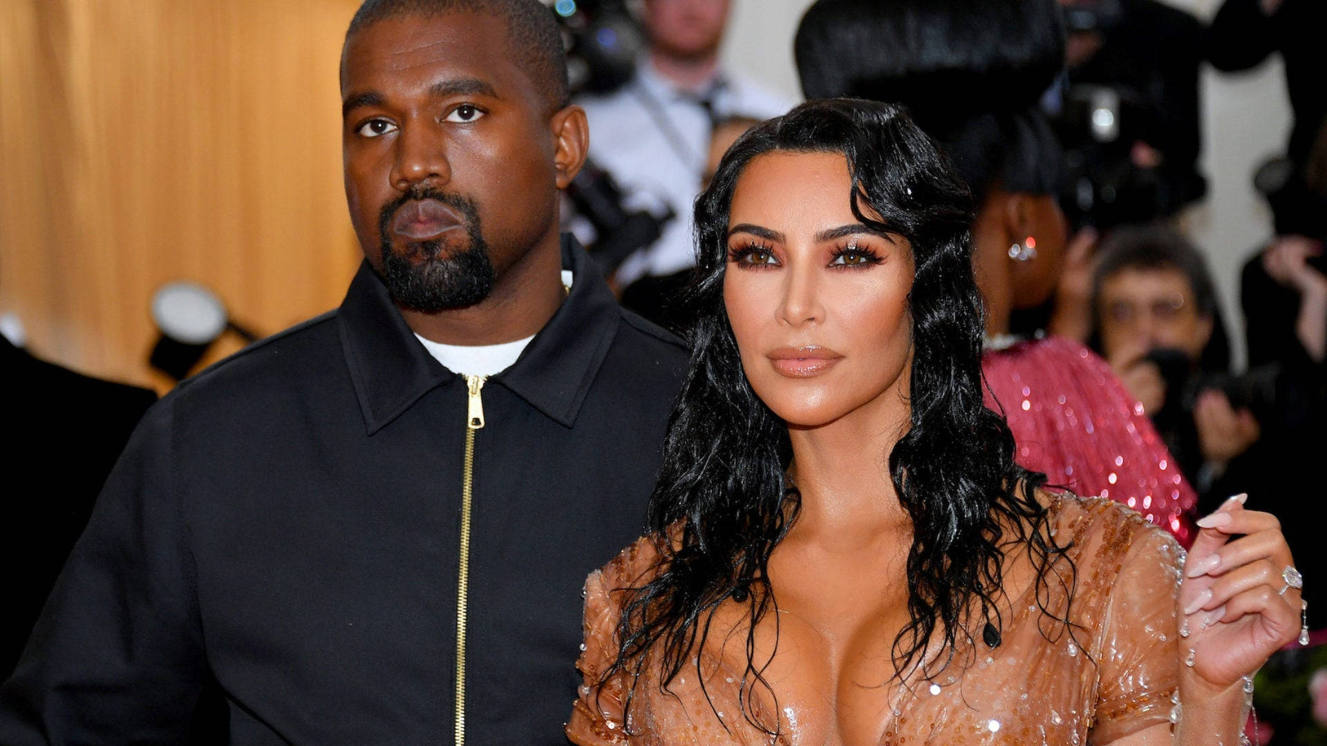 Kim Kardashian 桌布 壁紙 — Kanye West 和 Kim Kardashian 在一個華麗的活動中一起擺姿勢，背景有攝影師。