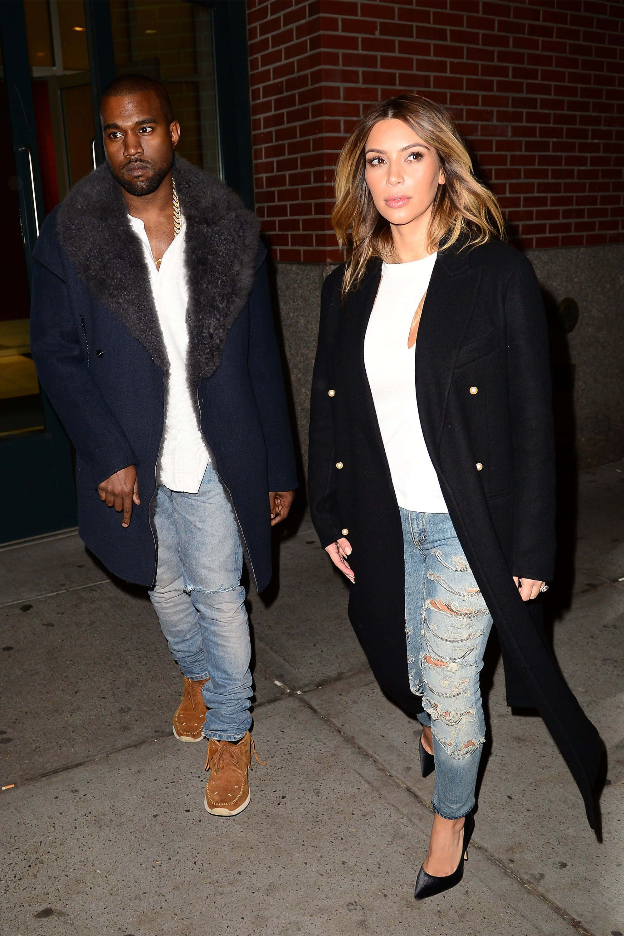 Matching Couple Profile 桌布 壁紙 — Kanye West 和 Kim Kardashian 晚上在城市人行道上並肩而行，穿著時尚的冬季外套和破洞牛仔褲。