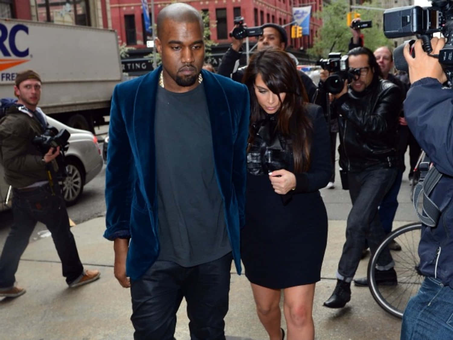 Paparazzi 桌布 壁紙 — Kanye West 和 Kim Kardashian 在攝影師和記者包圍下走過城市人行道。