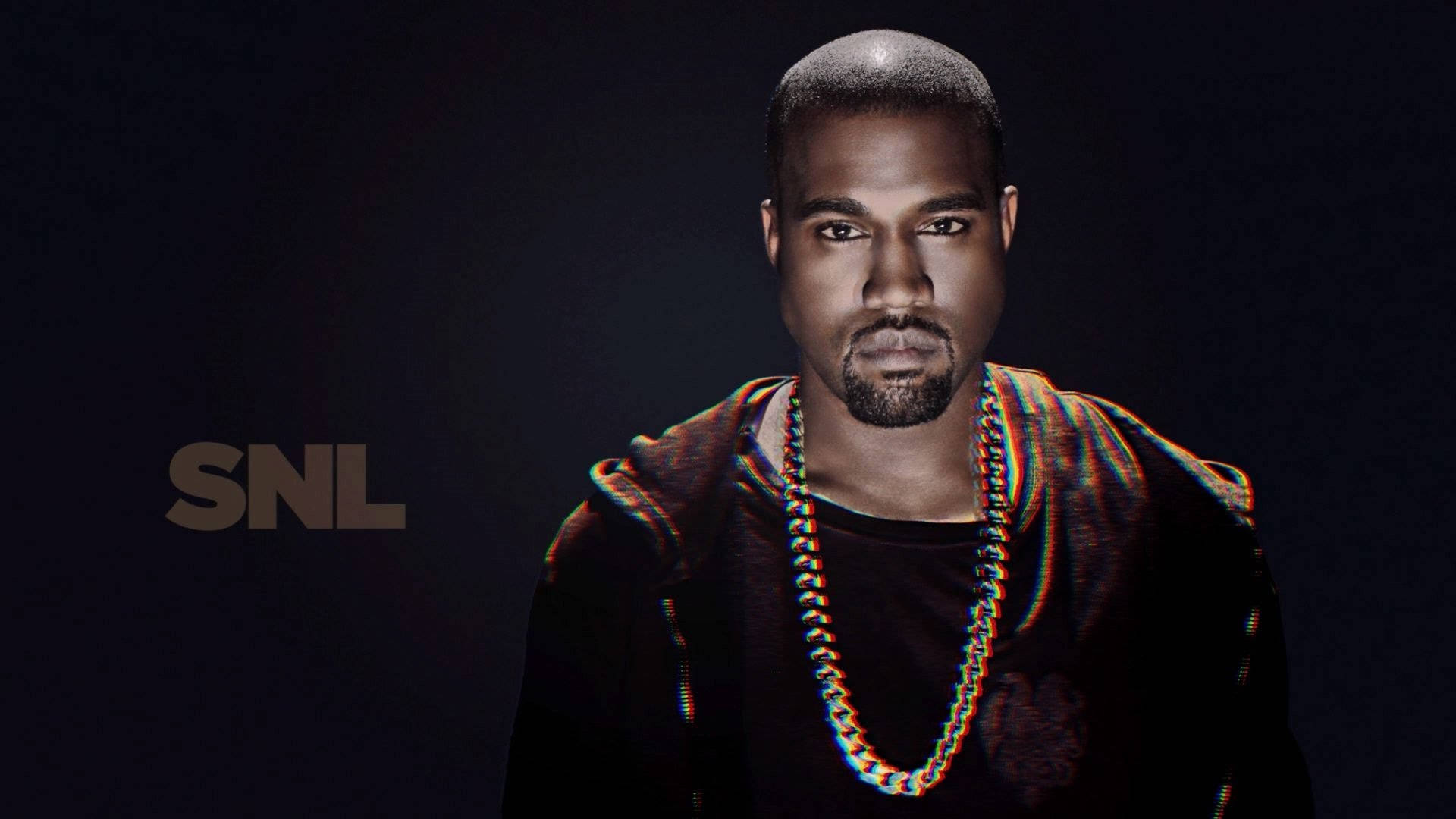 Kanye 桌布 壁紙 — Kanye West 戴著粗鏈項鍊，在深色背景和SNL標誌下，強烈凝視鏡頭。