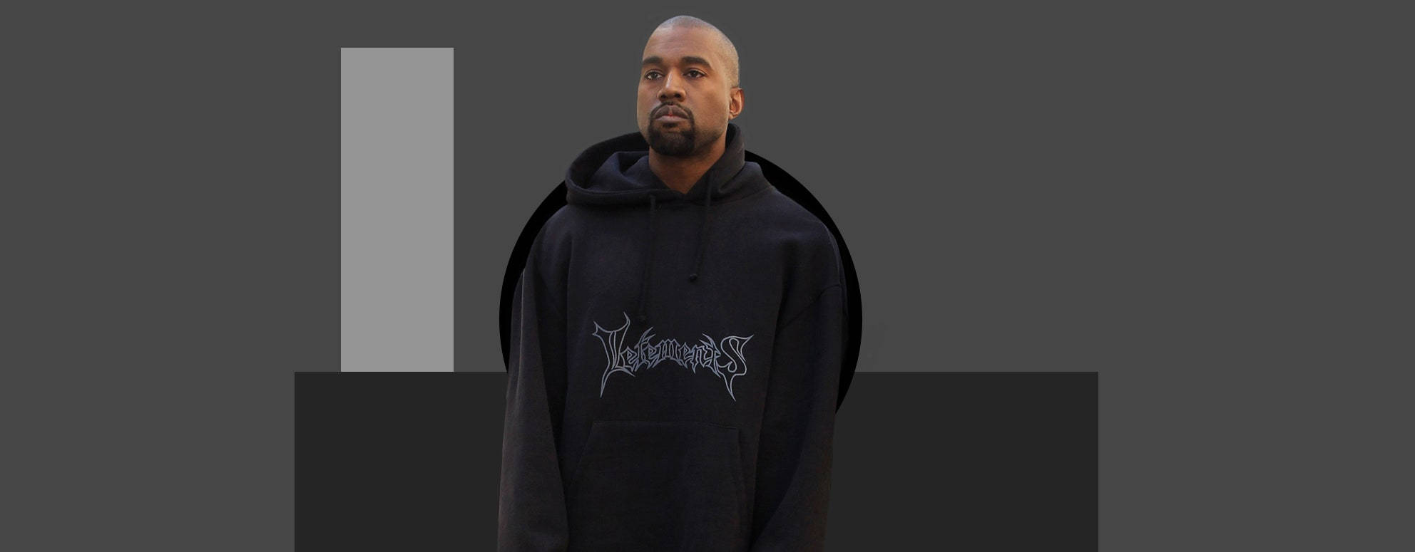 Vetements 桌布 壁紙 — Kanye West 身處簡約風格的工作室，身穿帶有銀色圖案的黑色連帽衫，背景為單色幾何圖案。