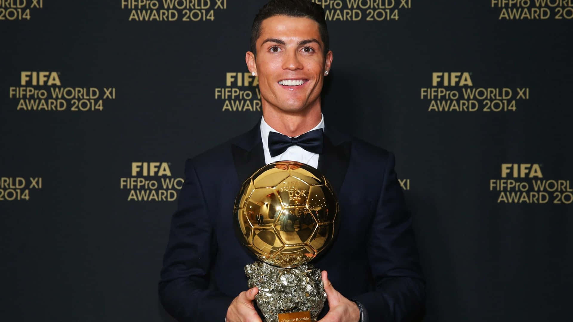  壁紙 — 克里斯蒂亞諾·羅納度身穿禮服，在2014年FIFA FIFPro世界最佳11人頒獎典禮上燦爛微笑，手持閃閃發光的金色足球獎盃。