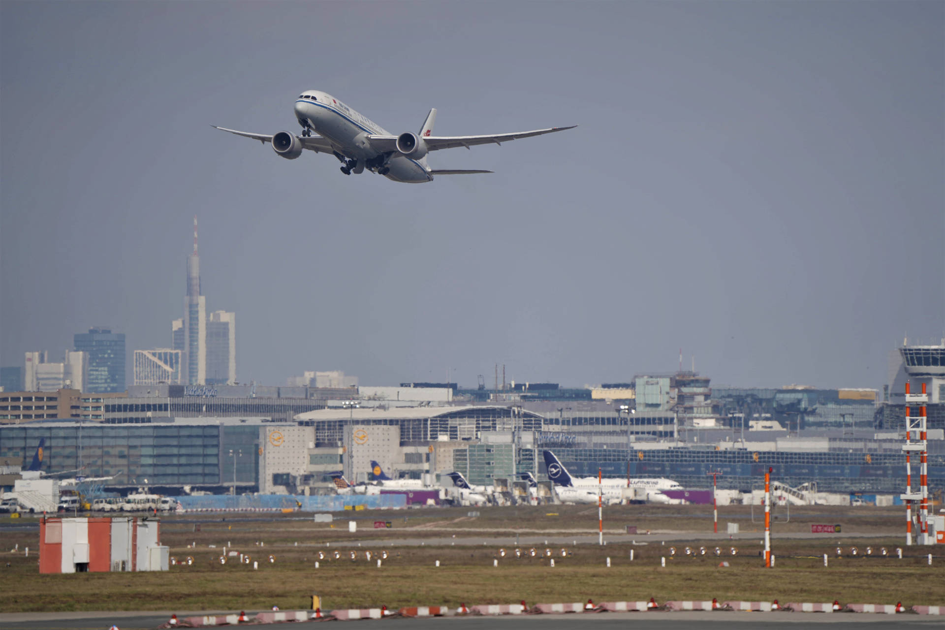 客機從現代化機場起飛，背景是城市天際線。 — 4K 飛機壁紙 壁紙