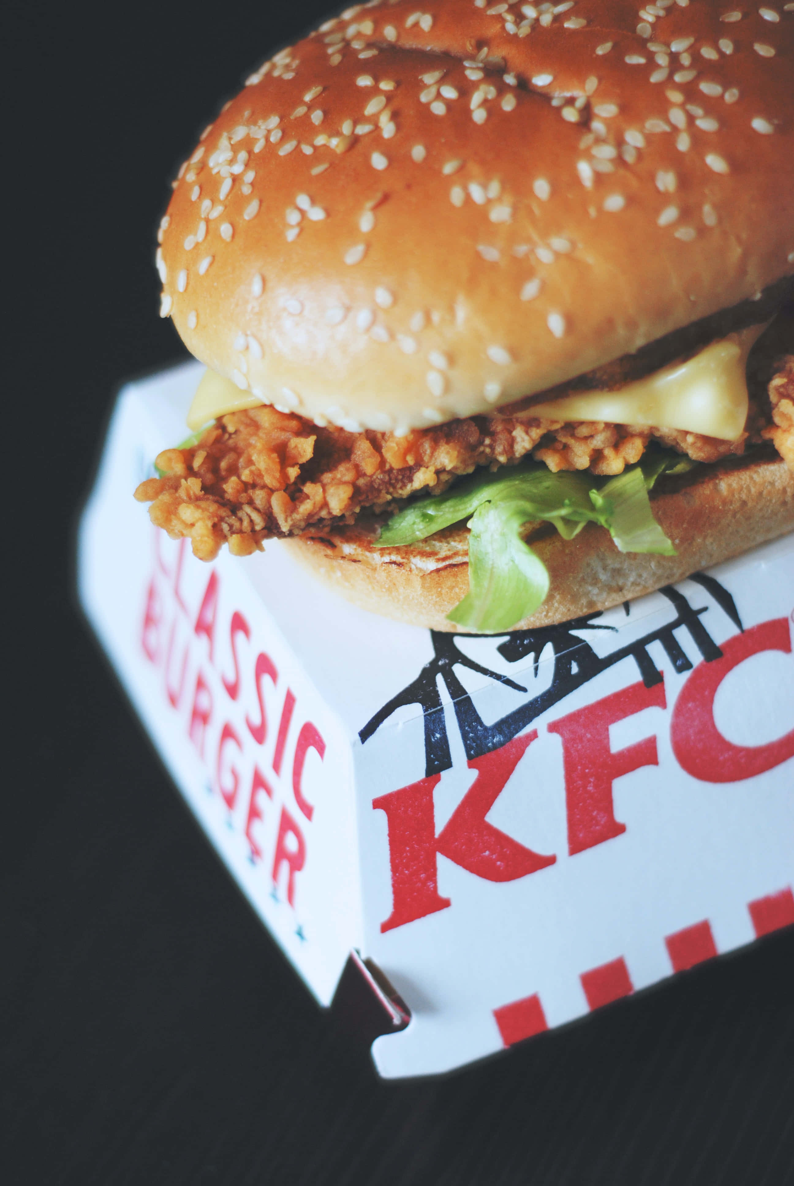Kfc 桌布 壁紙 — KFC經典漢堡盒中，一個酥脆炸雞漢堡配融化起司和生菜的特寫。