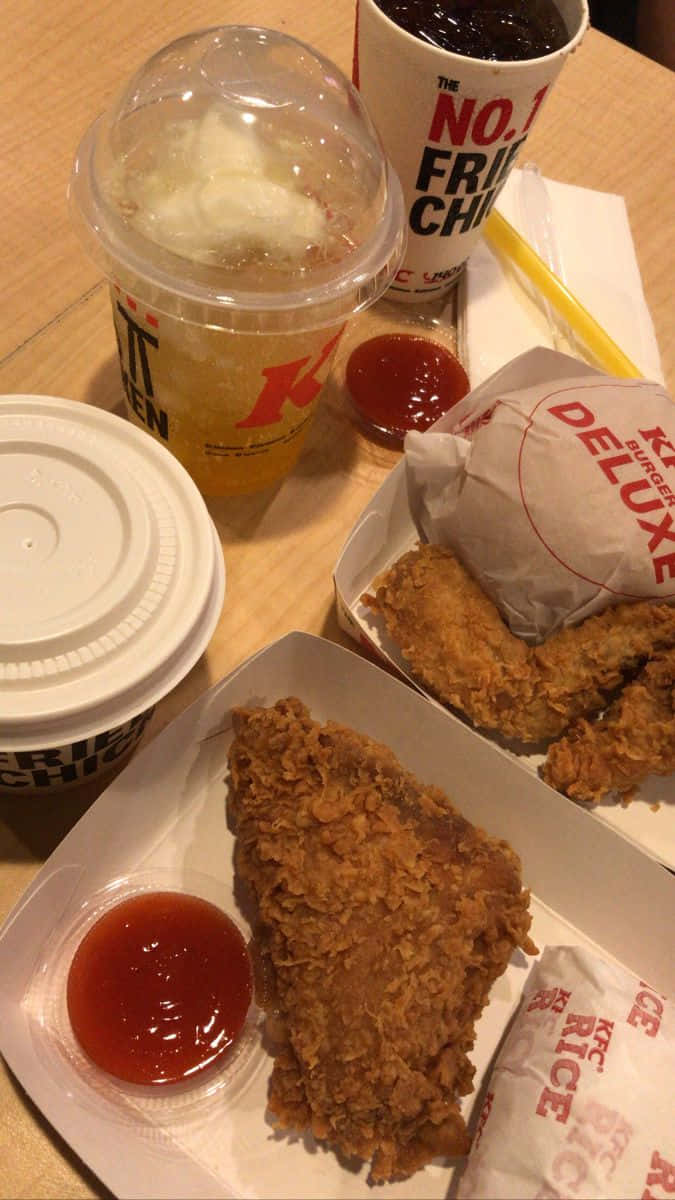 fried chicken 桌布 壁紙 — KFC香脆炸雞塊和飲品放在木桌上，附有番茄醬包的近距離特寫。
