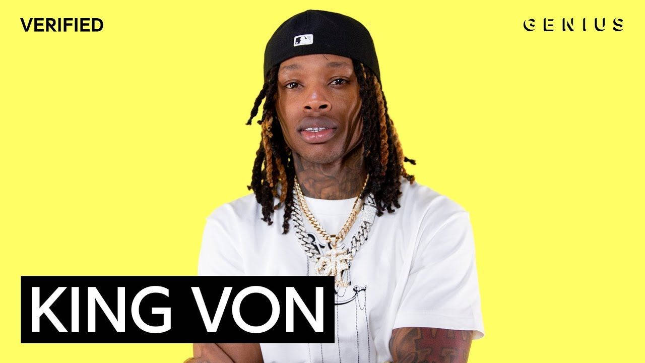 King Von 戴著黑色帽子和金鏈，在黃色背景前，附有文字。 — King Von 壁紙