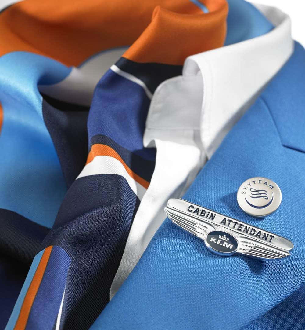Aircraft 桌布 壁紙 — KLM 機艙服務員藍色制服外套近照，配有 SkyTeam 徽章及橙藍條紋圍巾。