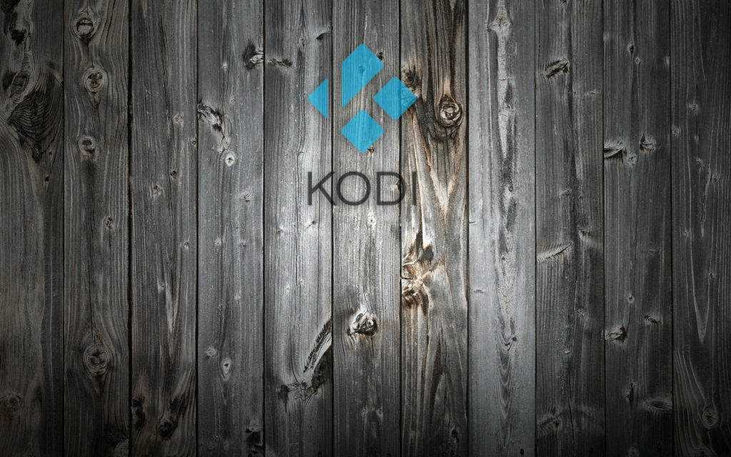 Kodi 桌布 壁紙 — Kodi 標誌以藍色和灰色文字居中顯示在風化的深色木板上，木紋和節疤清晰可見。