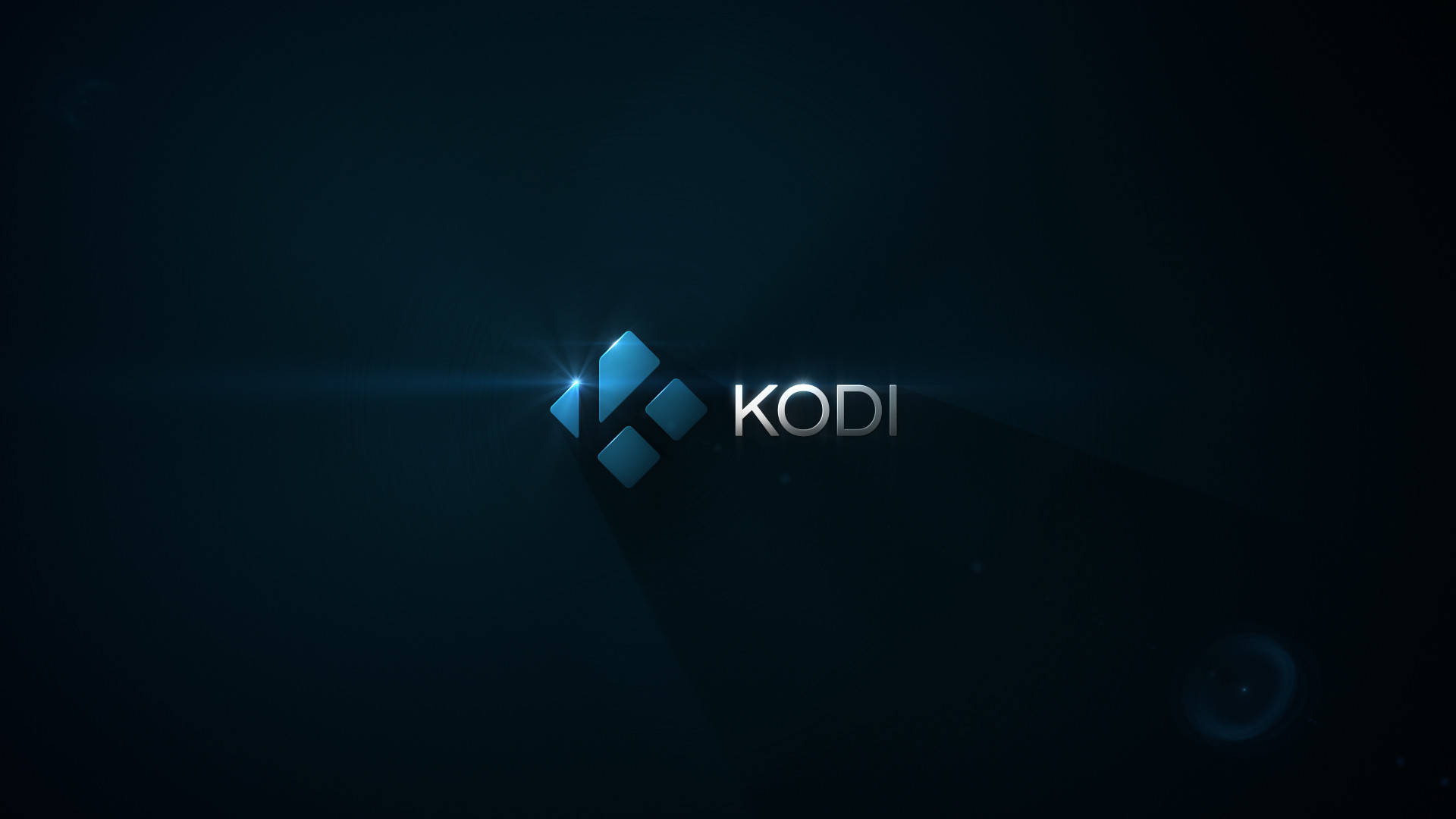 科迪 桌布 壁紙 — Kodi 標誌在黑暗背景上發出藍光，帶有鏡頭光暈和微妙的粒子效果。