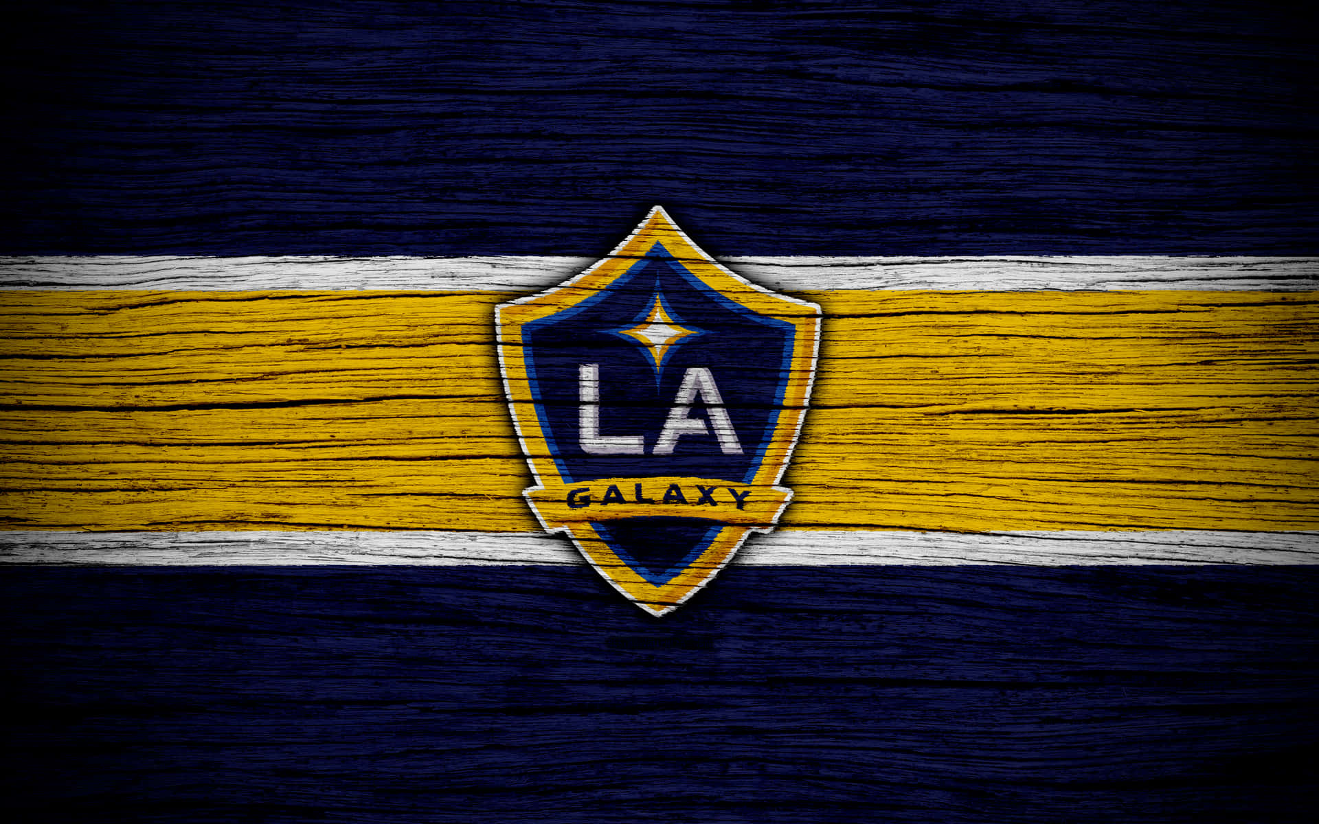 LA Galaxy 足球隊標誌，黃藍條紋木質背景。 — 4K 壁紙
