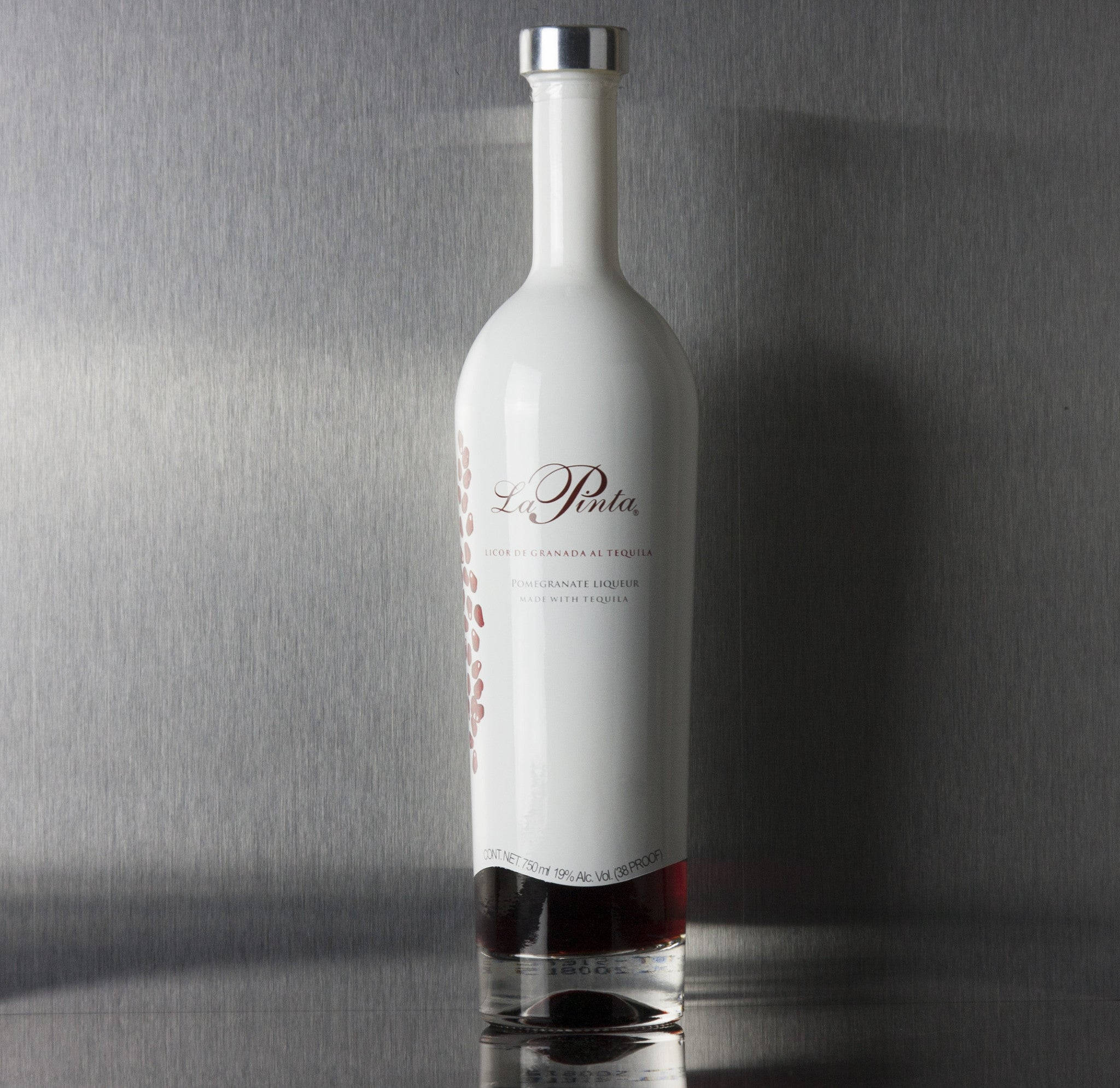 bottle 桌布 壁紙 — La Pinta 石榴利口酒的時尚白色瓶子，立於拉絲金屬背景上，帶有柔和陰影和反光表面。