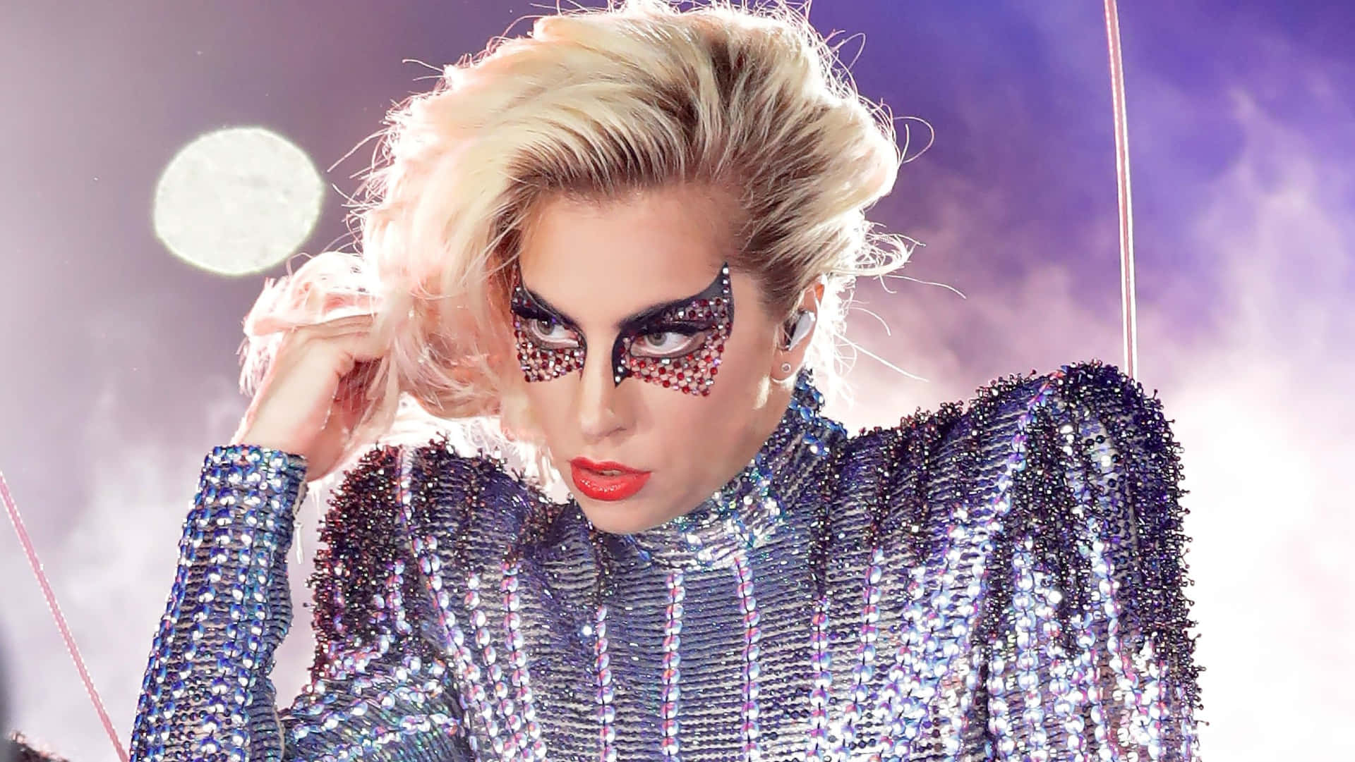 Celebrity 桌布 壁紙 — Lady Gaga 身穿閃亮銀色亮片服裝，搭配大膽紅唇和閃爍眼妝，背景是紫色迷霧舞台。